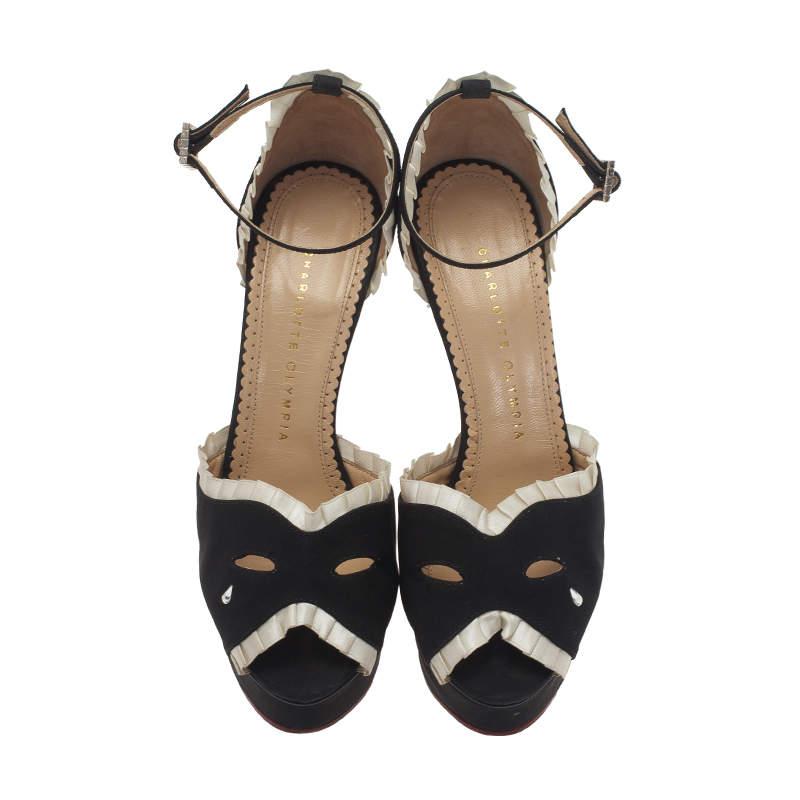 Ajoutez une touche de style incomparable avec ces sandales noires Charlotte Olympia. Confectionnées en satin noir, elles présentent des finitions en satin plissé crème, des empeignes à découpe effet masque avec goutte de cristal clair et des orteils