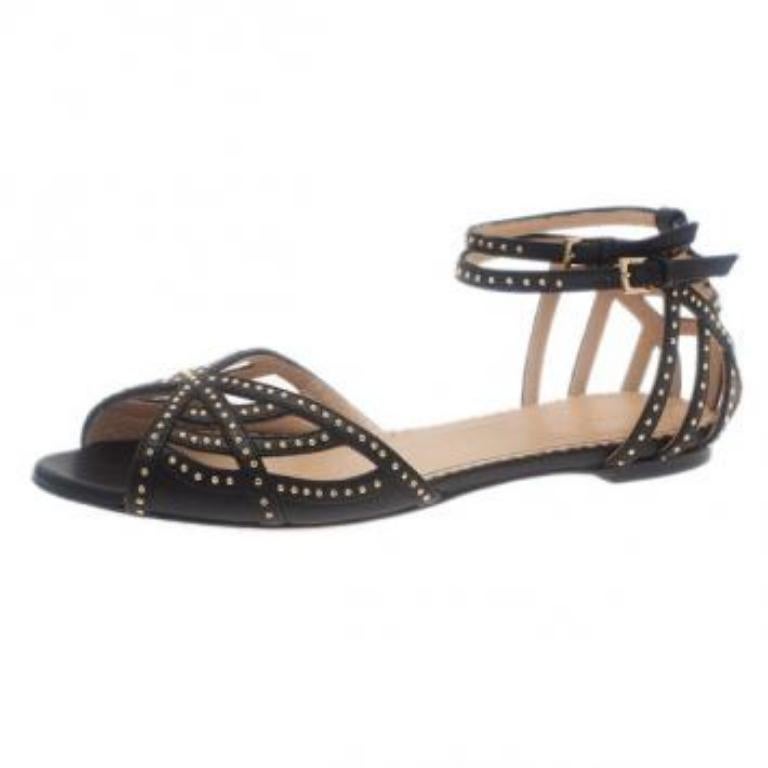 Ces sandales Charlotte Olympia se marieront parfaitement avec n'importe quel look. Confectionnés en cuir noir souple, ils présentent des motifs à lanières sur l'empeigne, rehaussés de clous dorés. Elles sont dotées de brides de cheville réglables
