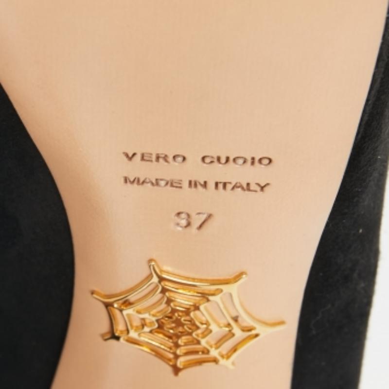 Les bottines Minerva Web de Charlotte Olympia sont présentées en daim noir et soulignées par le motif en toile d'araignée signature de la marque sur l'empeigne. Les chaussures sont montées sur des plateformes et des talons de 14 cm.
