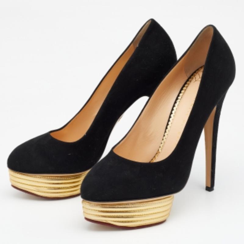 Llama la atención con este par de zapatos de salón Dolly de Charlotte Olympia. Elaborada con ante negro y forrada con piel en las plantillas, esta creación se embellece con tacones altos y plataformas doradas.