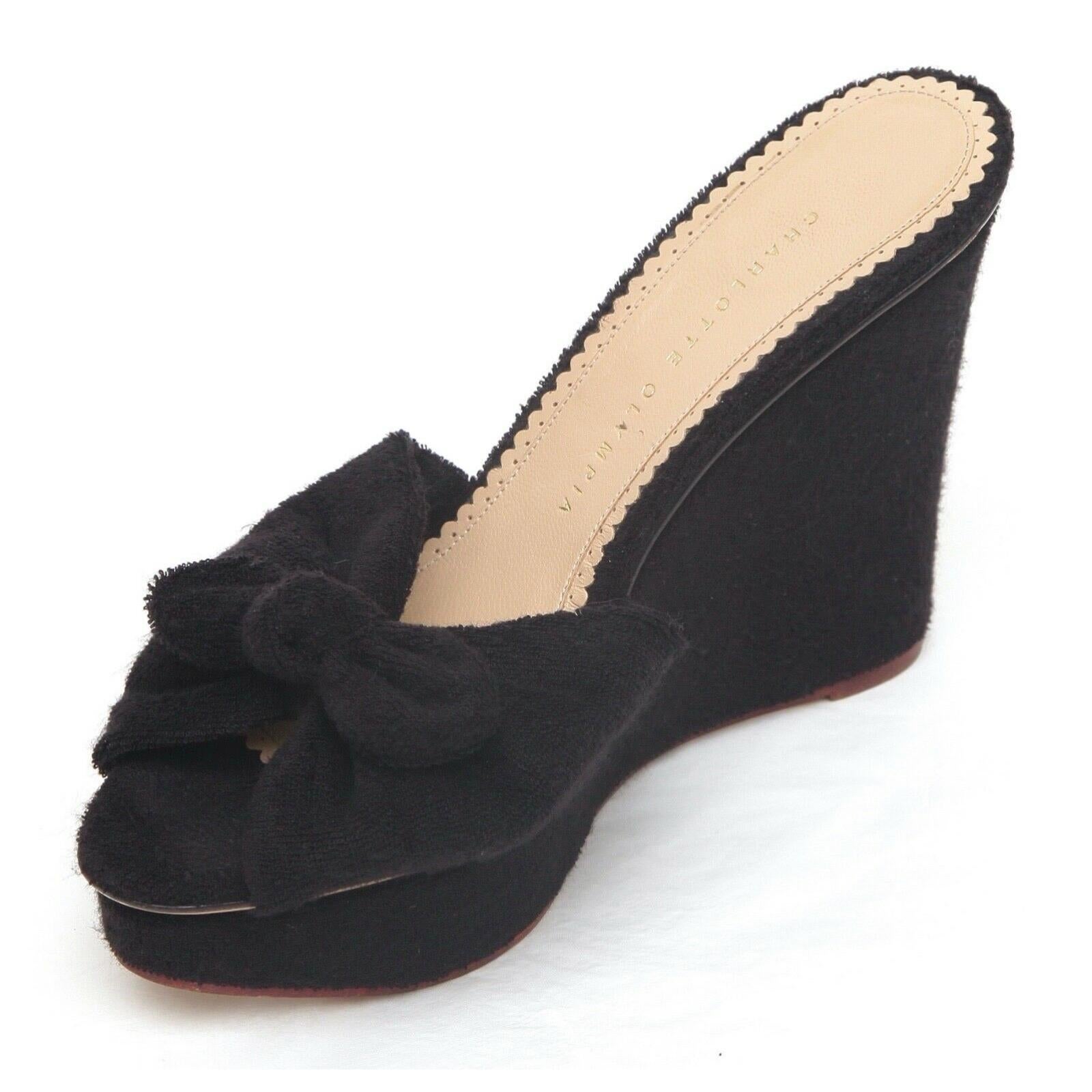 GUARANTEED AUTHENTIC CHARLOTTE OLYMPIA BLACK TERRY CLOTH WEDGE SANDALS

Design:
- Black terry cloth upper.
- Bow at vamp.
- Terry covered platform and wedge.
- Leather lining and sole.

Size: 38.5

Measurements (Approximate):
- Insole, 10