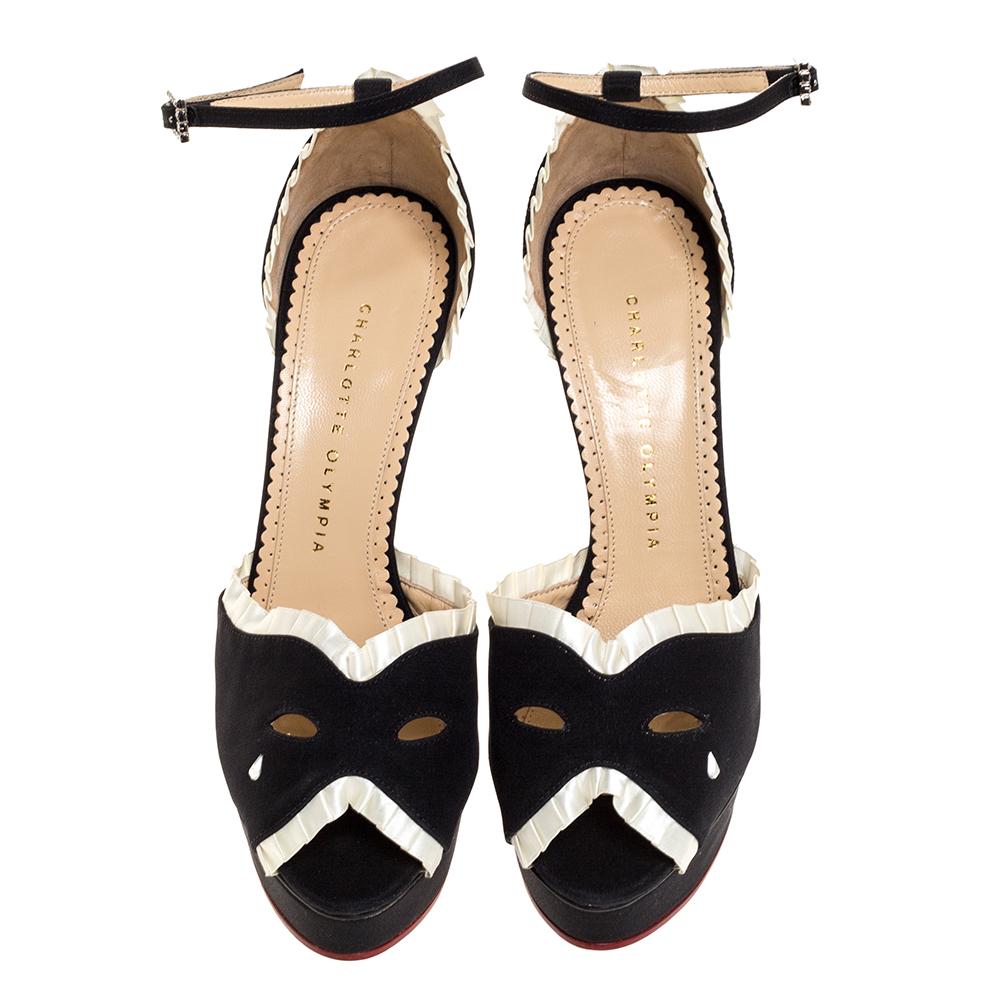 Add an unrivaled touch of style with this Charlotte Olympia black Masquerade sandals. Crafted from black satin, they feature white pleated satin trims, mask-effect cutout vamps with clear crystal teardrop, and peep toes. They also come with
