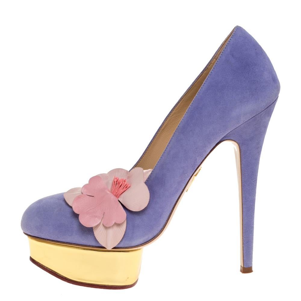 Own this meticulously designed pair of Charlotte Olympia pumps today and dazzle everyone whenever you step out! Crafted out of blue suede, this creation is from their Dolly collection. They have been beautified with lovely orchid appliques, 15 CM