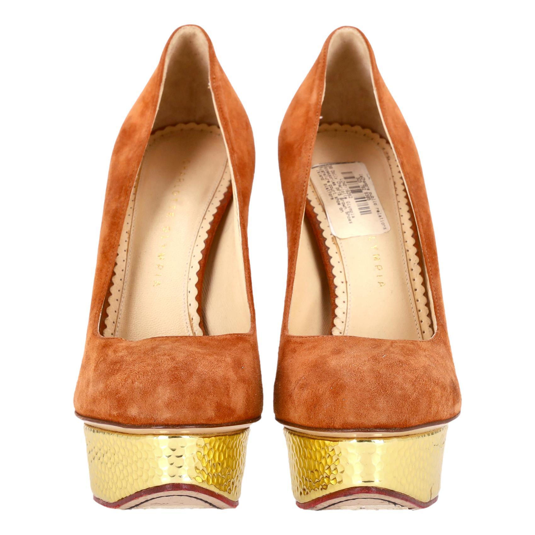 Escarpins Dolly à plateforme métallique de Charlotte Olympia

Talons Dolly en daim brun orangé, dotés d'une plateforme Island en métal doré.

Elles sont dotées d'un talon aiguille et du motif toile d'araignée caractéristique de la marque sur la