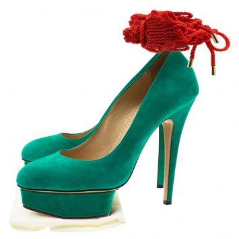 Diese Charlotte Olympia Dolly Pumps bringen jeden Look zum Strahlen. Diese witzigen Schuhe mit spitzer Spitze sind aus grünem Wildleder gefertigt und werden durch rote Kordelschnüre am Knöchel ergänzt. Die überzogenen Plateaus sind mit 15,5 cm