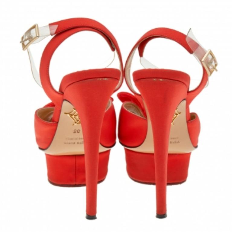 ¡Charlotte Olympia no deja ocasión para impresionarnos! Estas preciosas sandalias Serena darán un toque impresionante a tus pies. Están confeccionadas con satén naranja en el exterior y presentan un motivo de lazo en los peep-toes, plataformas, un