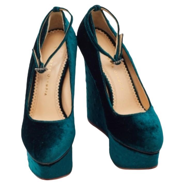 Champion a chic look with this pair of Charlotte Olympia pumps. Created from strict effect velvet, it is defined by platforms, wedges, and an ankle buckle clsoure.