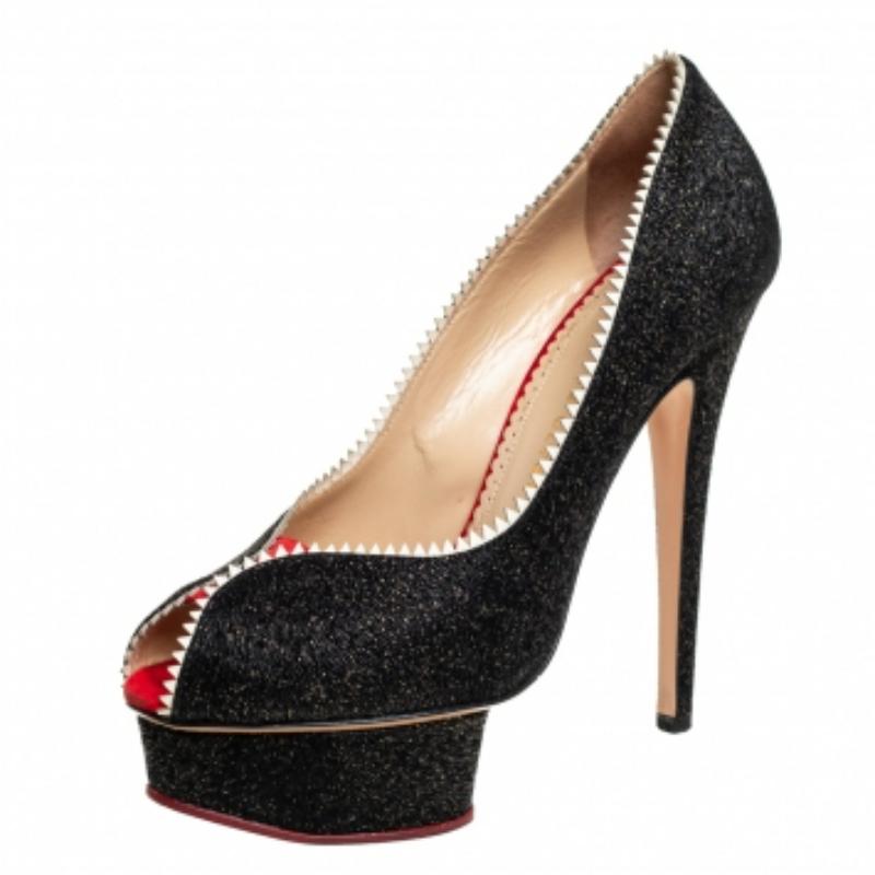 These pumps from Charlotte Olympia are love at first sight! The black beauties are exquisitely crafted from glitter & patent leather and designed to please the eyes of the beholder. They flaunt contrast trims, peep toes, well-cut platforms and 14 cm