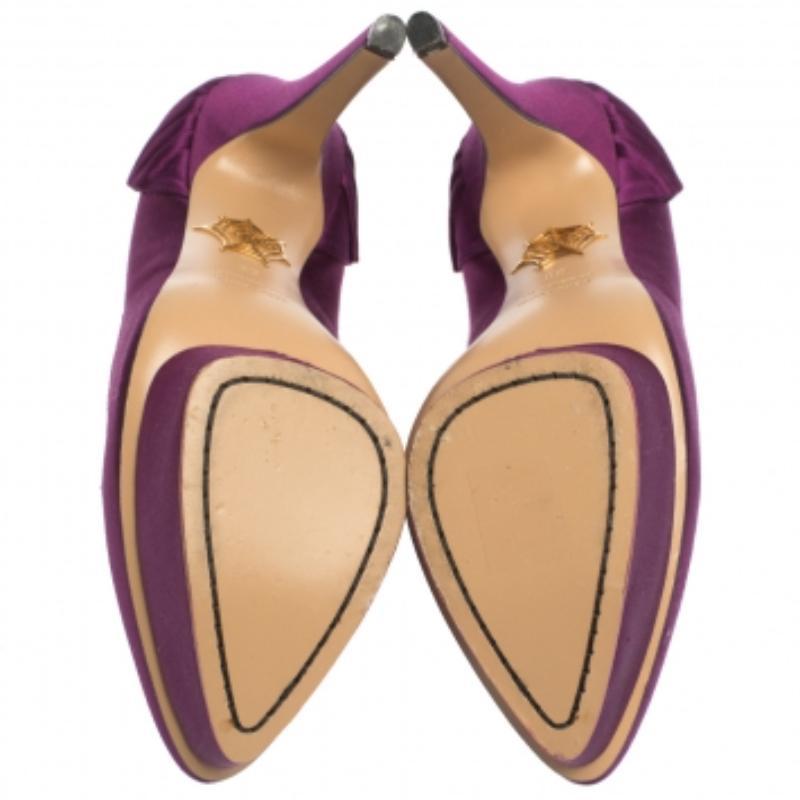 Aggiungi un tocco di eleganza al tuo abbigliamento con questo paio di décolleté ben fatte di Charlotte Olympia. Realizzate in raso, sono caratterizzate da plateau, tacchi alti e pieghe a ventaglio sui banconi. Questo paio di bellezze viola combina