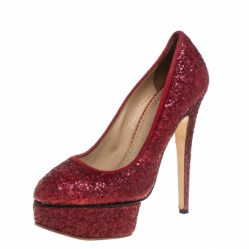Give your outfit a sparkling touch with these Charlotte Olympia Priscilla pumps. These stunning shoes feature red glitter, matching grosgrain trims, almond toe caps, and platforms. They are lined with supple beige leather and have Charlotte Olympia