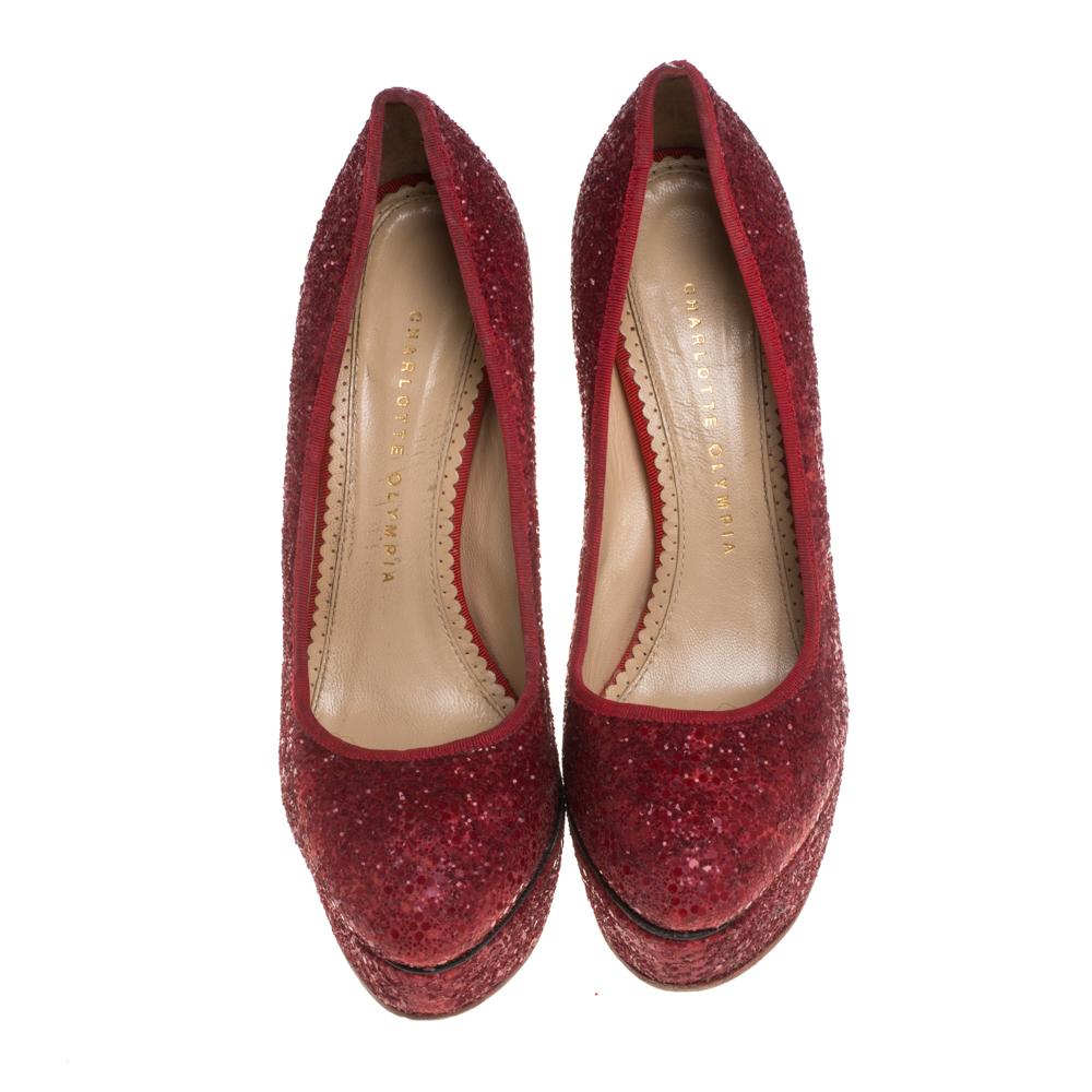 Give your outfit a sparkling touch with these Charlotte Olympia Priscilla pumps. These stunning shoes feature red glitter, matching grosgrain trims, almond toe caps, and platforms. They are lined with supple beige leather and have Charlotte Olympia