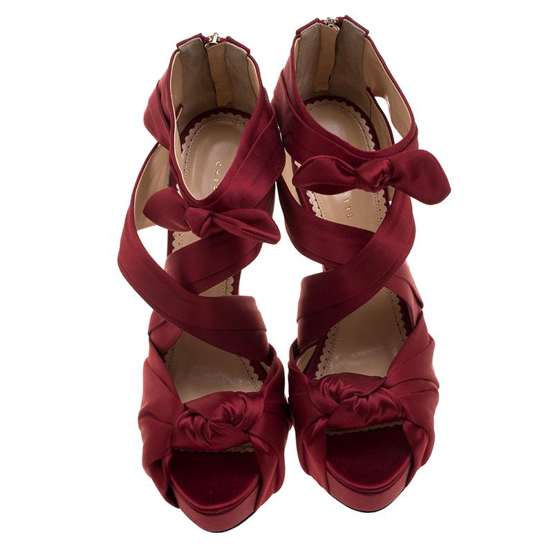 These Charlotte Olympia platform sandals are just the thing to add charm to your party outfits. These Andrea sandals sport crossed satin straps in red hue which are further beautifully knotted like a ribbon on the vamp and the ankle strap. Completed