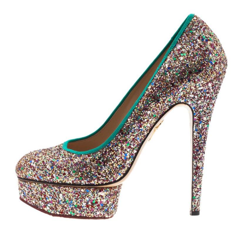 Give your outfit a sparkling touch with these fabulous Charlotte Olympia pumps. These stunning shoes feature multicolored glitter, a green grosgrain trims, almond toe caps, and platforms. They are lined with supple beige leather and have Charlotte
