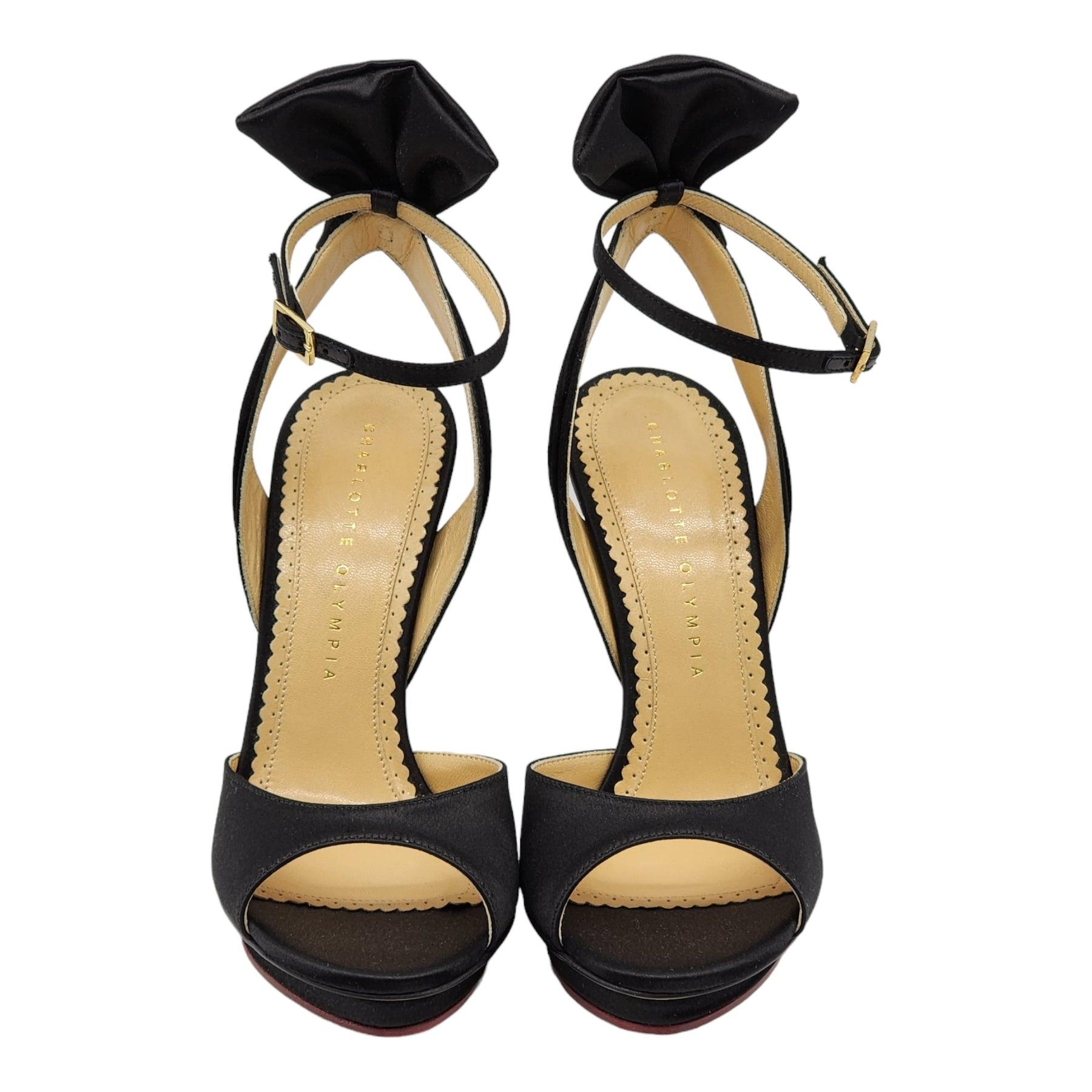 Charlotte Olympia Wallace Bow-Back Satin Evening Pumps Black.

Additional information:
Material: Silk & Leather interior and outsole
Color: Black
Size: 5 US
Country: Italy
Dimension: Heel 5