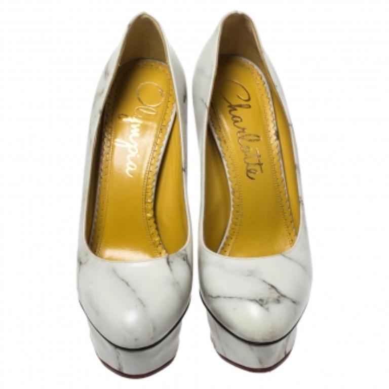 Own this meticulously designed pair of Charlotte Olympia pumps today and dazzle everyone whenever you step out! Crafted out of leather and exhibiting a marble-print design, these pumps are from their Dolly collection. They are lined with leather on