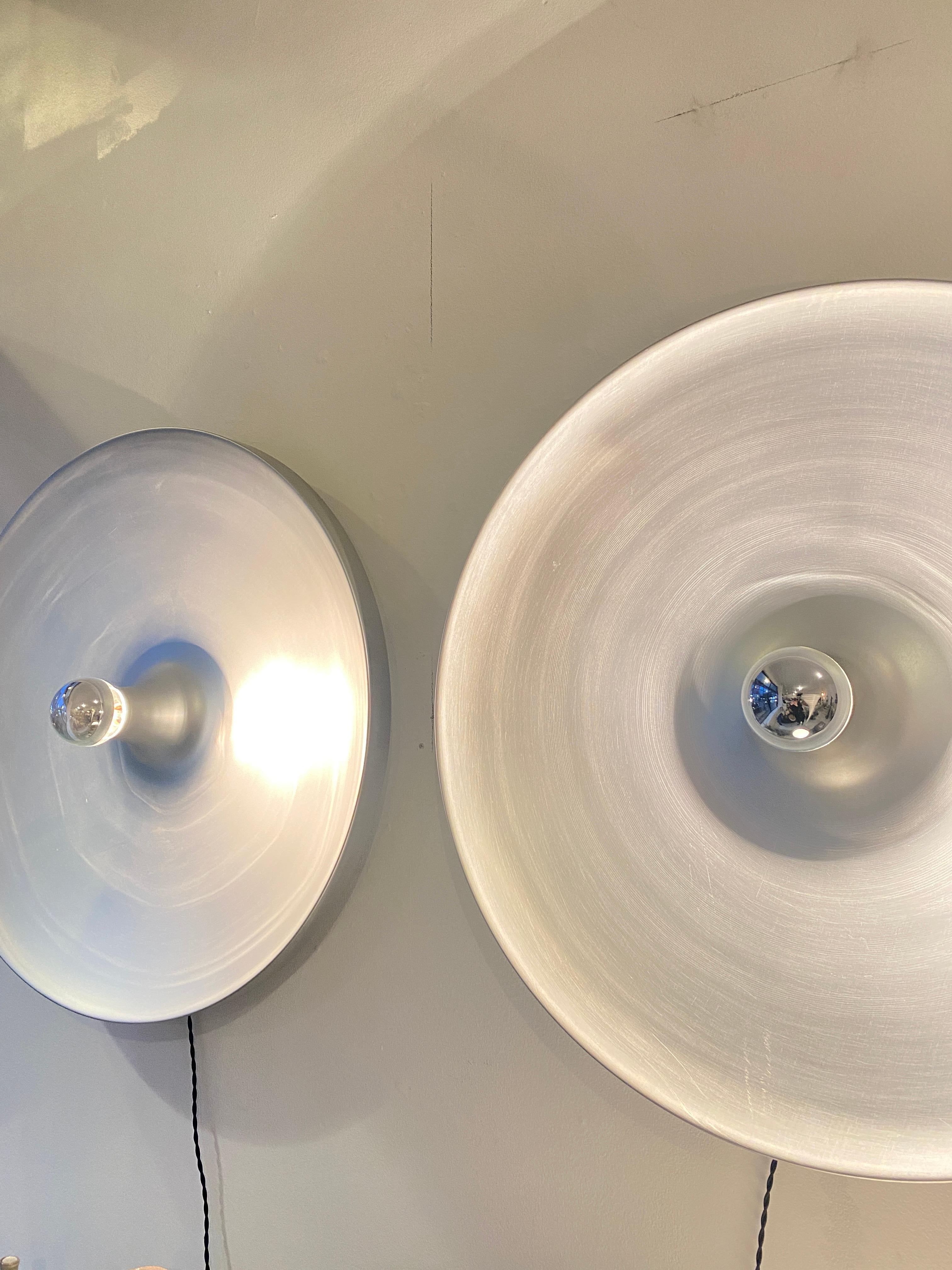Charlotte Perriand selected these light sconces for the French ski resort she was designed Les Arcs. They were edition by Staff Leuchten circa 1960. Brushed stainless steel. 
Shown with a 40w silver tip bulb. 