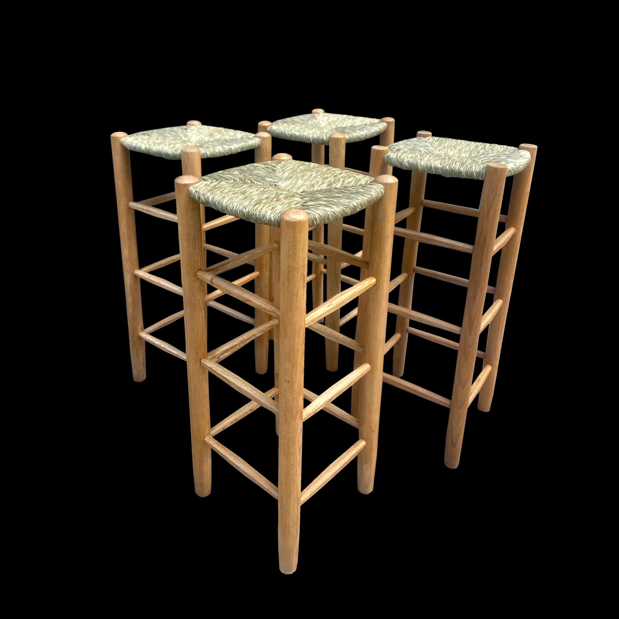A rare set of four high ash stools by Charlotte Perriand, Avoriaz bar stools. The straw seats have just been reupholstered in 