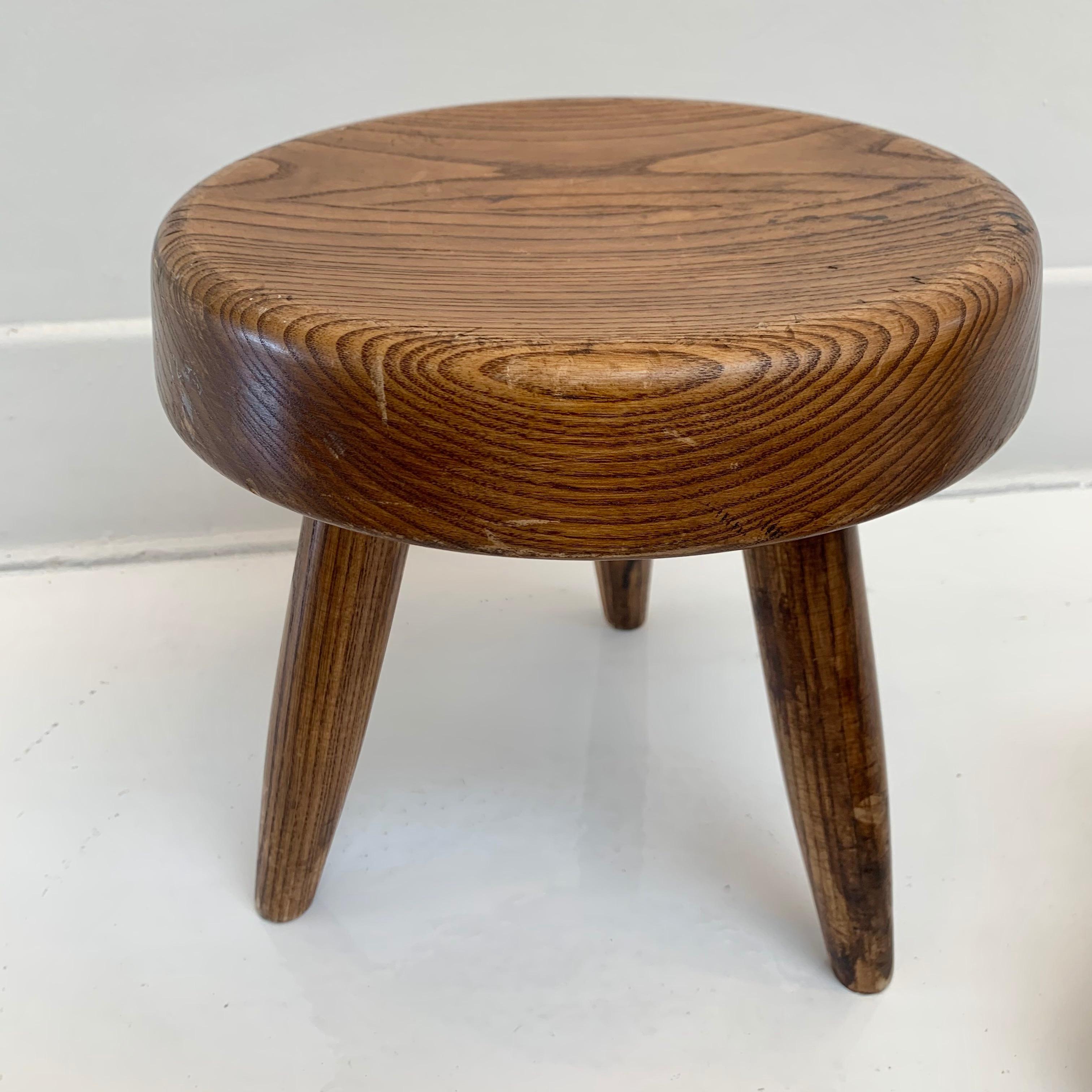 Collectible oak stool by Charlotte Perriand in France, Circa 1953. Two available. Priced individually. Very good condition with slight wear and excellent patina. 

 