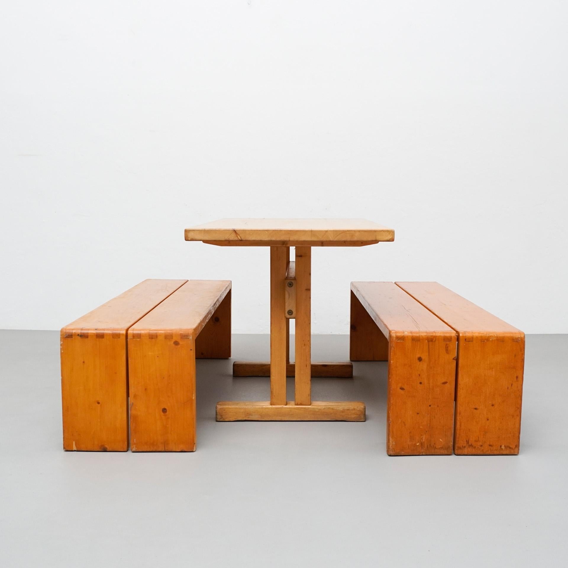 Set of table and benches designed by Charlotte Perriand for Les Arcs ski Resort, circa 1960, manufactured in France.

In good original condition, with minor wear consistent with age and use, preserving a beautiful patina.

Dimensions:
Table: D