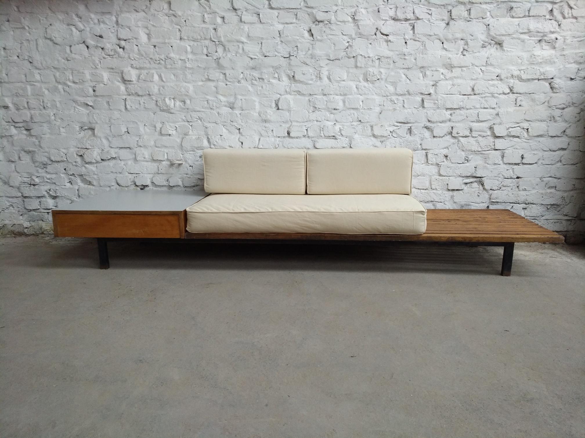 Fantastic patinated early slatted bench designed by Charlotte Perriand, 1959 France, for the homes of the Miferma mining company in the city of Cansado, Mauritania.
This bench comes with recently fabric upholstered foam cushions for a more