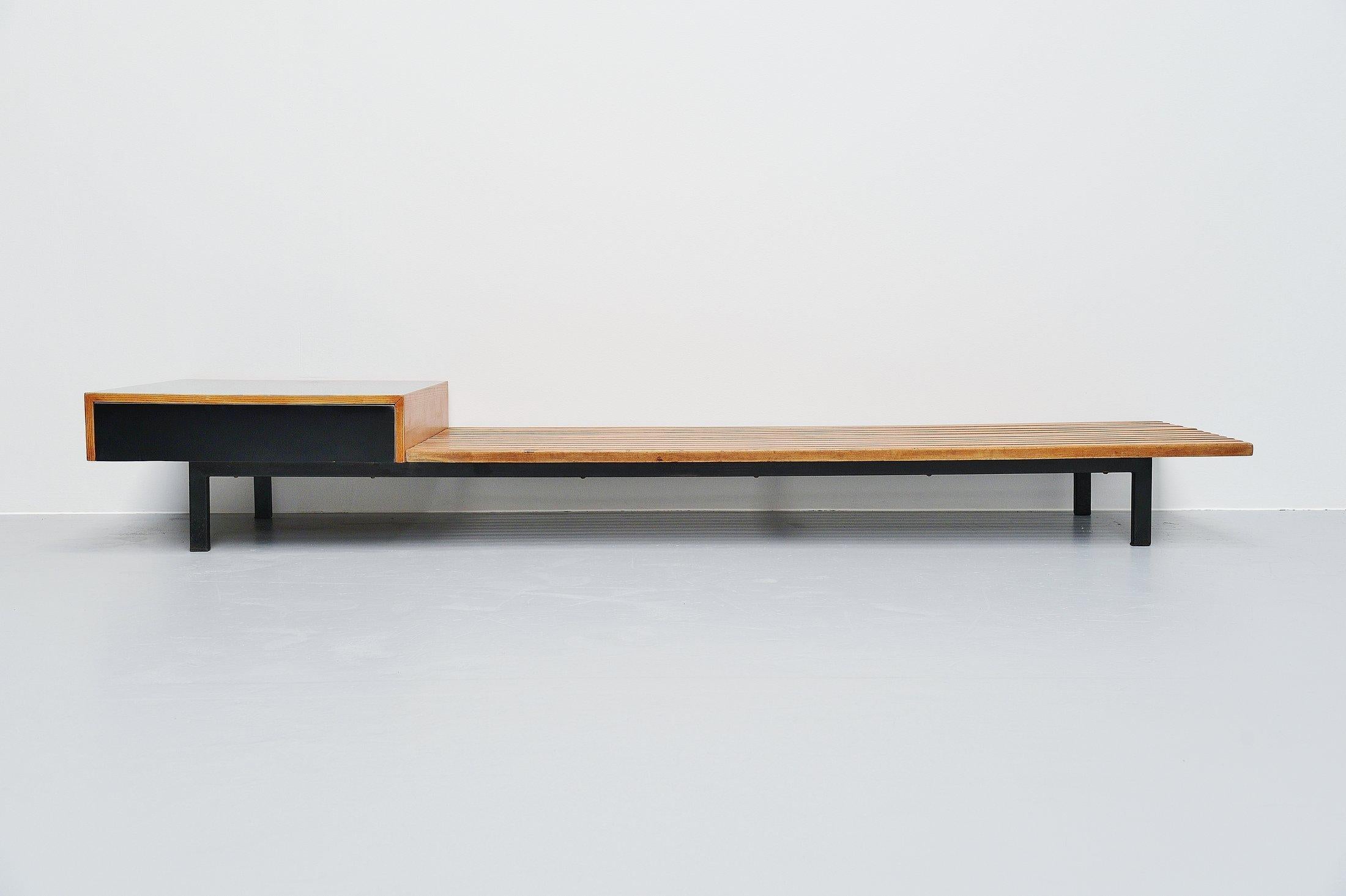Fantastic large slat bench designed by Charlotte Perriand for the Cite Cansado, Mauritania, and manufactured by Steph Simon, circa 1958. This bench was made of solid teak wooden slats and has a black metal frame. This rare bench has a drawer unit on