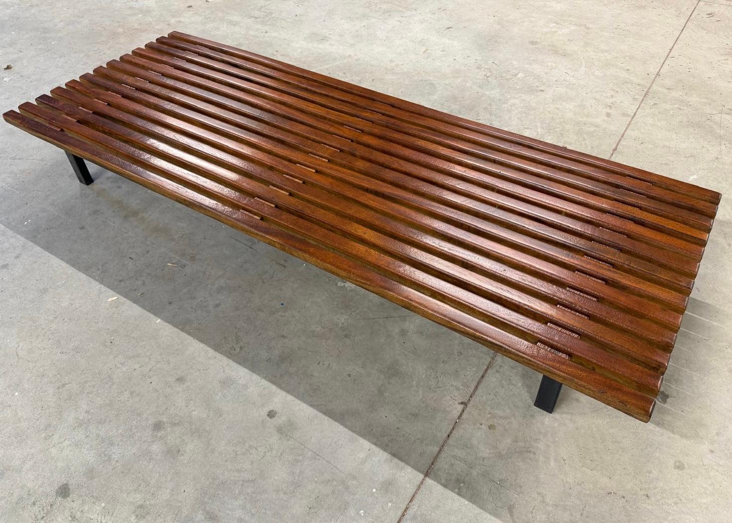 Bench designed by Charlotte Perriand, circa 1950. Manufactured by Steph Simon (France), circa 1950. 
Mahogany wood, lacquered metal frame and legs. 
Signs of age, patina, and the traces of use enhance the character of this piece. Here we see the