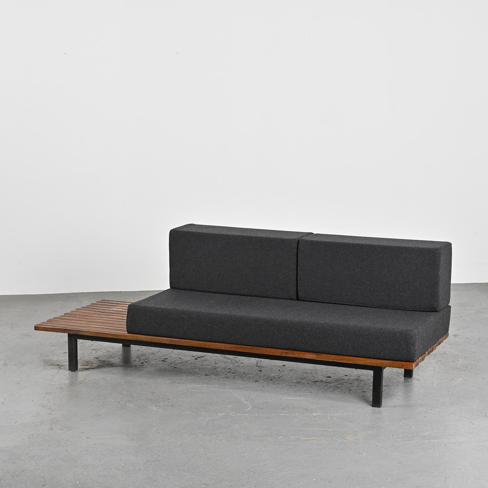 By Charlotte Perriand, a thirteen mahogany slats bench resting on black lacquered metal legs. It can also be stunning as a low table in a living room.

The mattress and cushions have be renovated in dark grey Nobilis woolen cloth.

Cansado is a