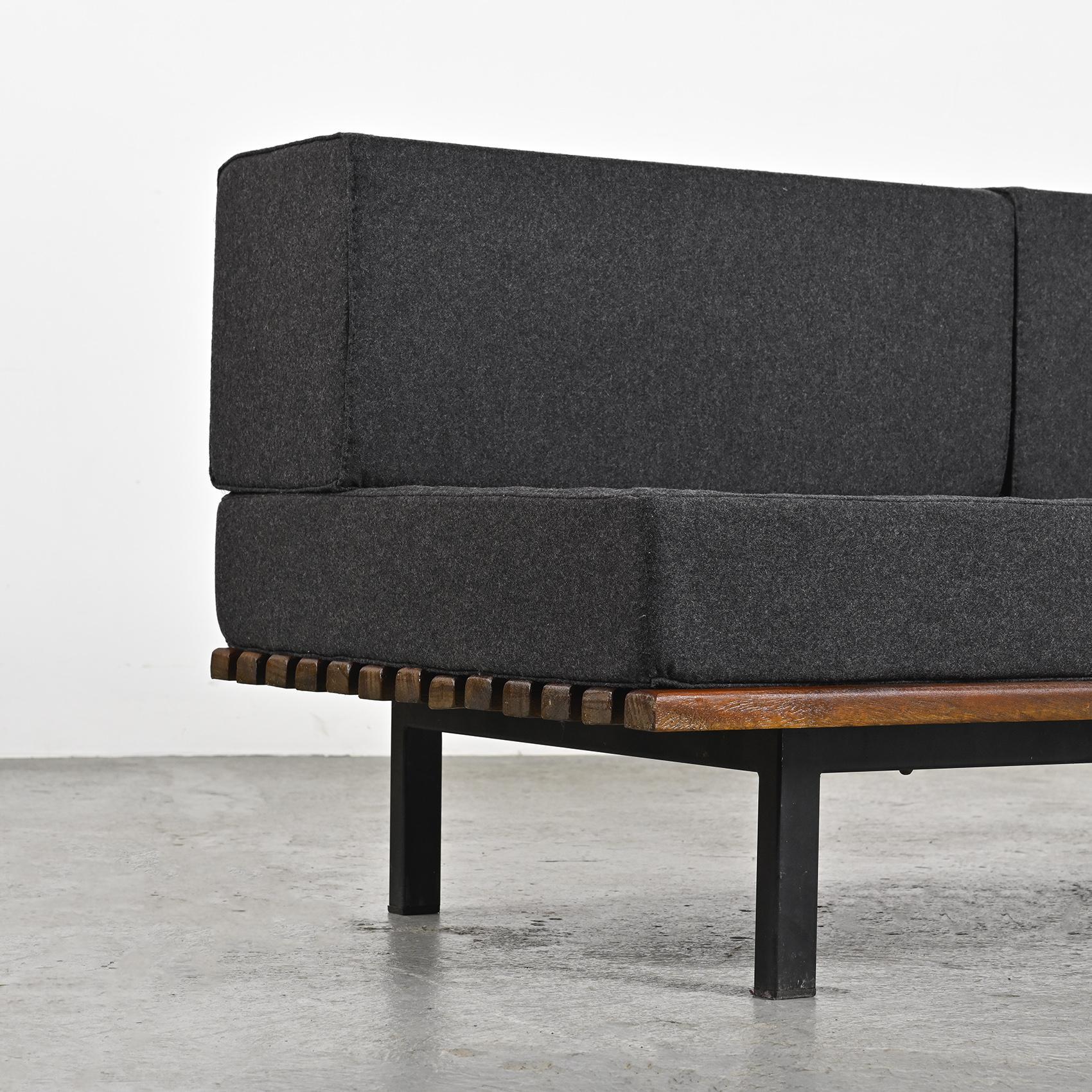By Charlotte Perriand, a thirteen mahogany slats bench resting on black lacquered metal legs. It can also be stunning as a low table in a living room.

The mattress and cushions have be renovated in dark grey Nobilis woolen cloth.

Cansado is a