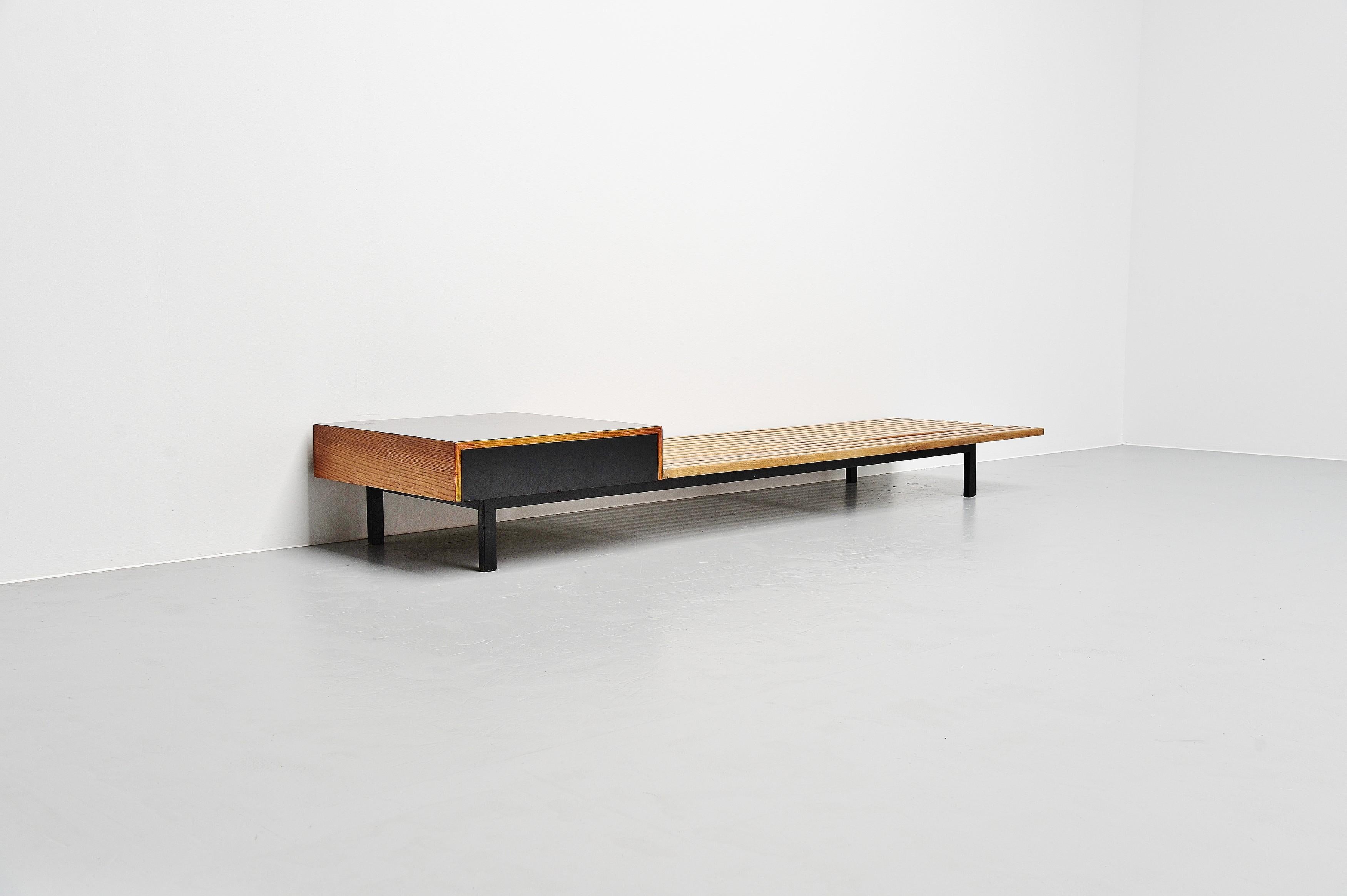 Large slat bench designed by Charlotte Perriand for the Cite Cansado, Mauritania, and manufactured by Steph Simon ca 1958. This bench was made of solid teak wooden slats and has a black metal frame. This rare bench has a drawer unit on the left