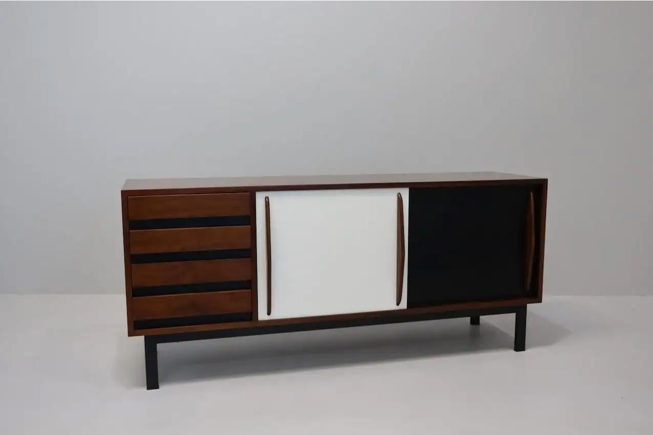 Sideboard designed by Charlotte Perriand, circa 1960. Manufactured by Steph Simon (France). Steel base, wood structure and grips, lacquered sliding doors. In good original condition, with minor wear consistent with age and use, complete restored.