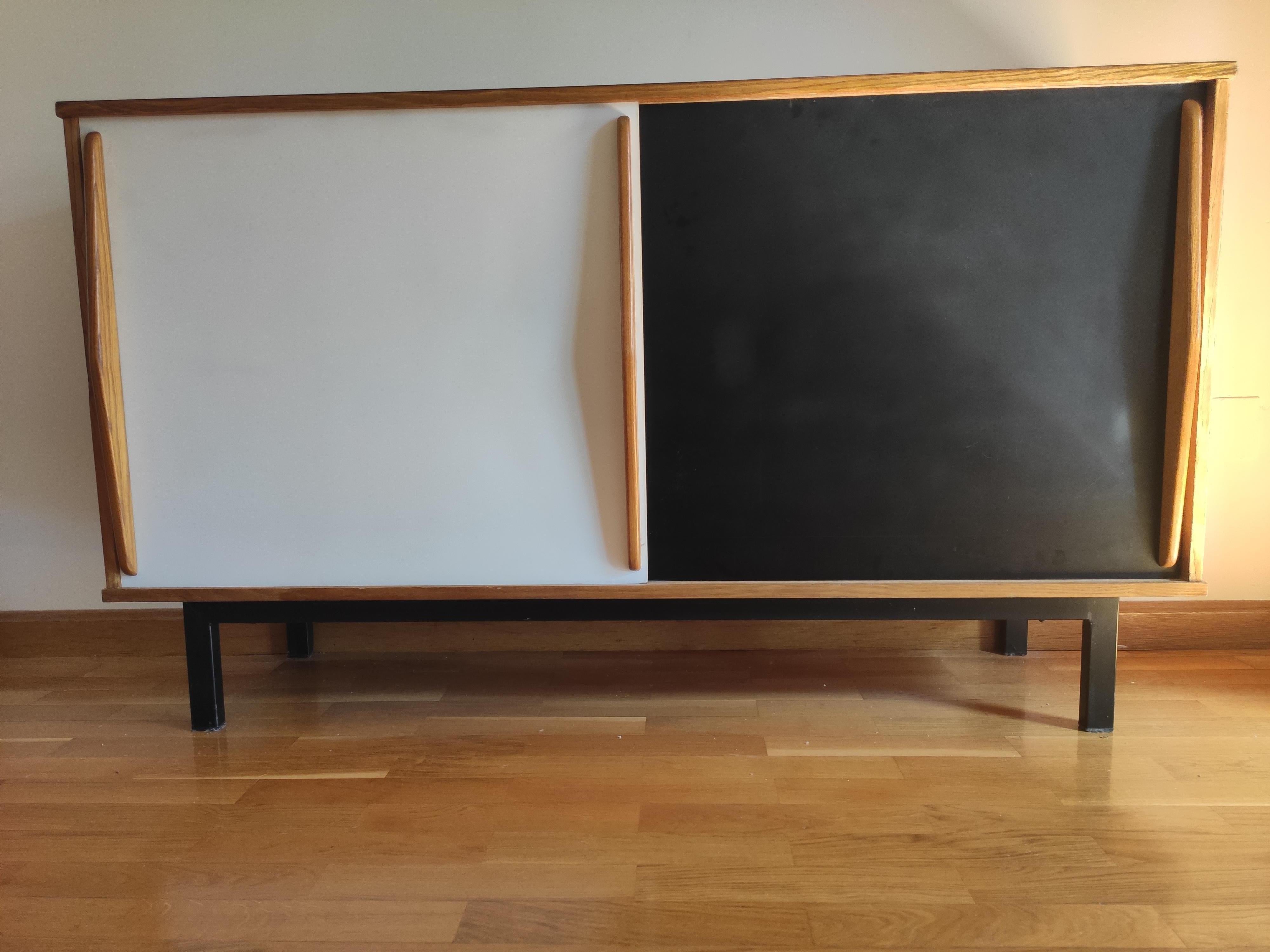 Sideboard designed by Charlotte Perriand, circa 1950.
Edited by Steph Simon (France)
Steel base,wood structure and grips, formica sliding doors.

Provenence: Cansado, Mauritania (Africa)

In original condition, with wear consistent with age