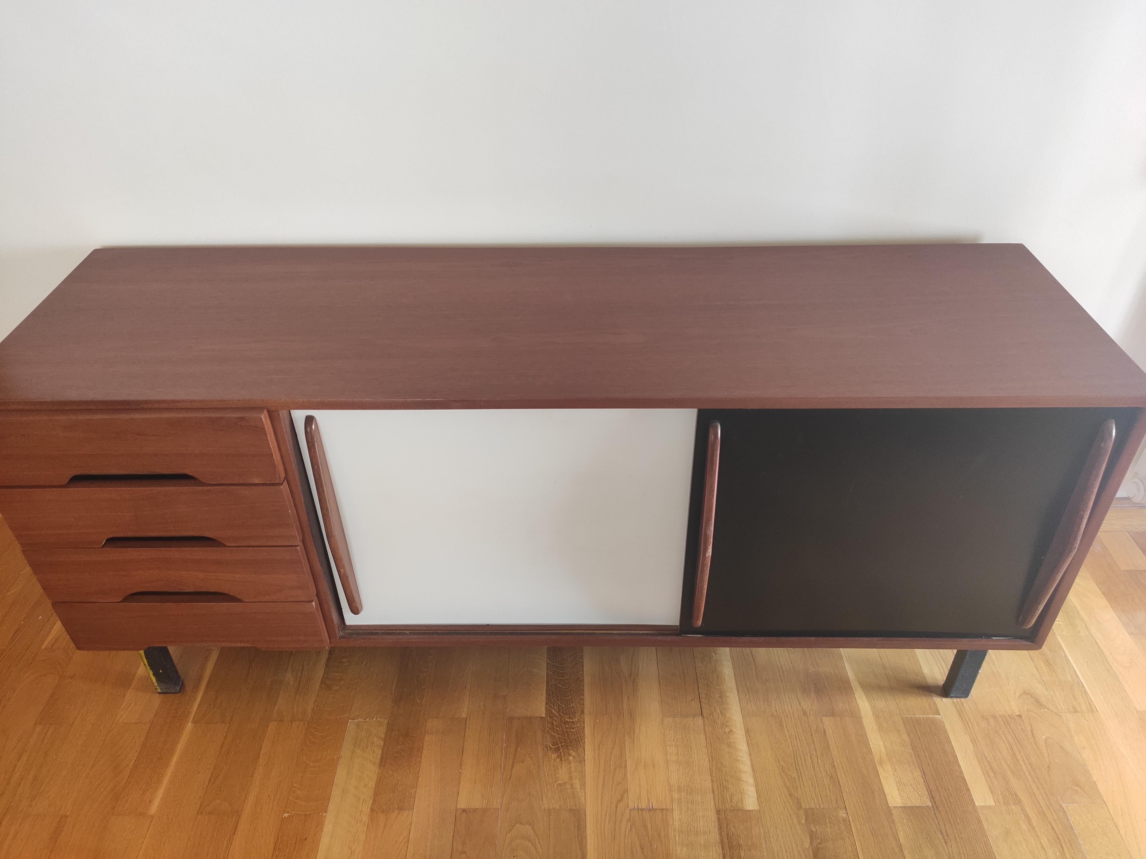 Sideboard designed by Charlotte Perriand, circa 1950.
Edited by Steph Simon, (France).
Steel base, wood structure and grips, lacquered sliding doors.

Provenance: Cansado, Mauritania (Africa).

In good original condition, with minor wear