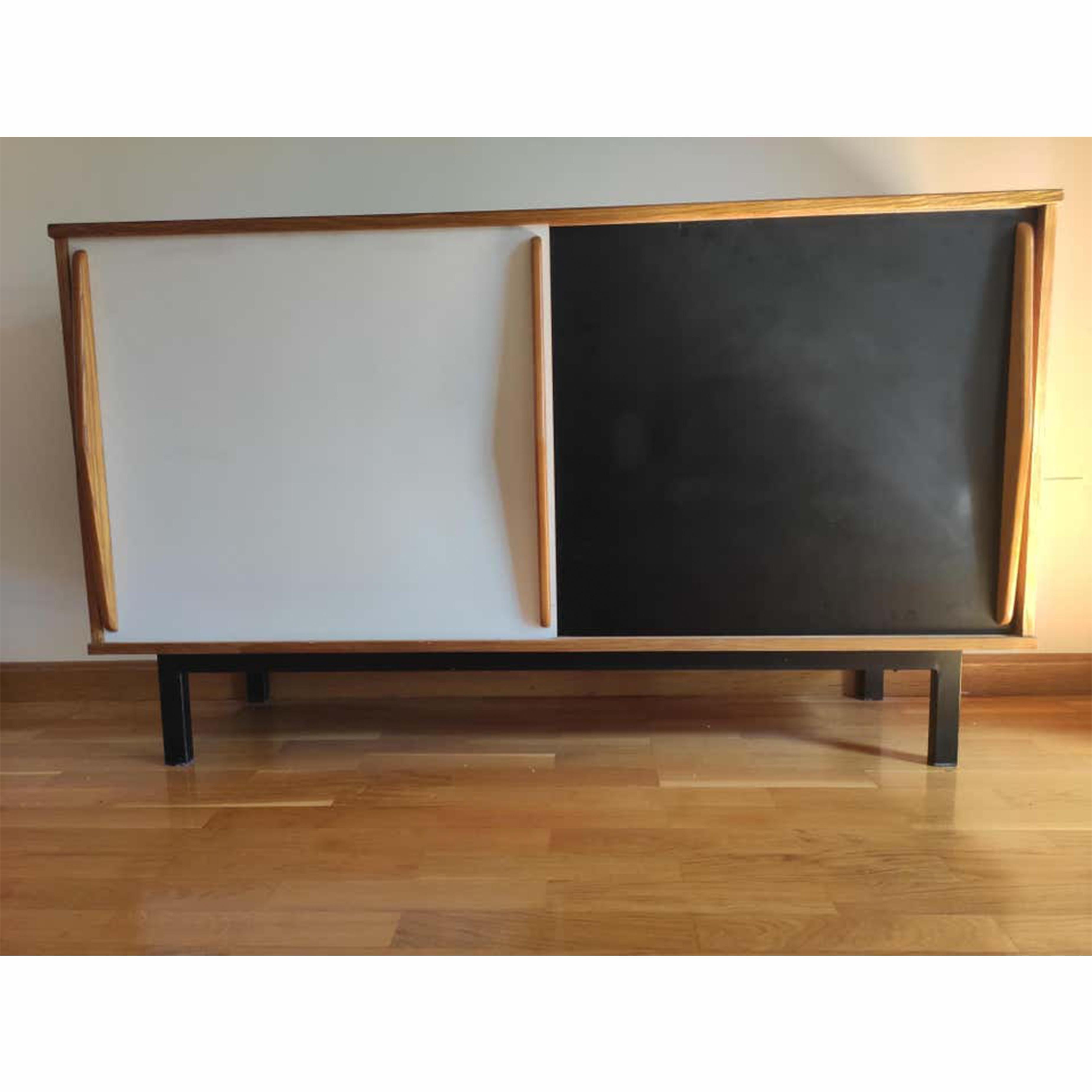 Sideboard designed by Charlotte Perriand, circa 1950.
Edited by Steph Simon, (France)
Steel base, wood structure and grips, Formica sliding doors.

Provenence: Cansado, Mauritania (Africa)

In original condition, with wear consistent with age