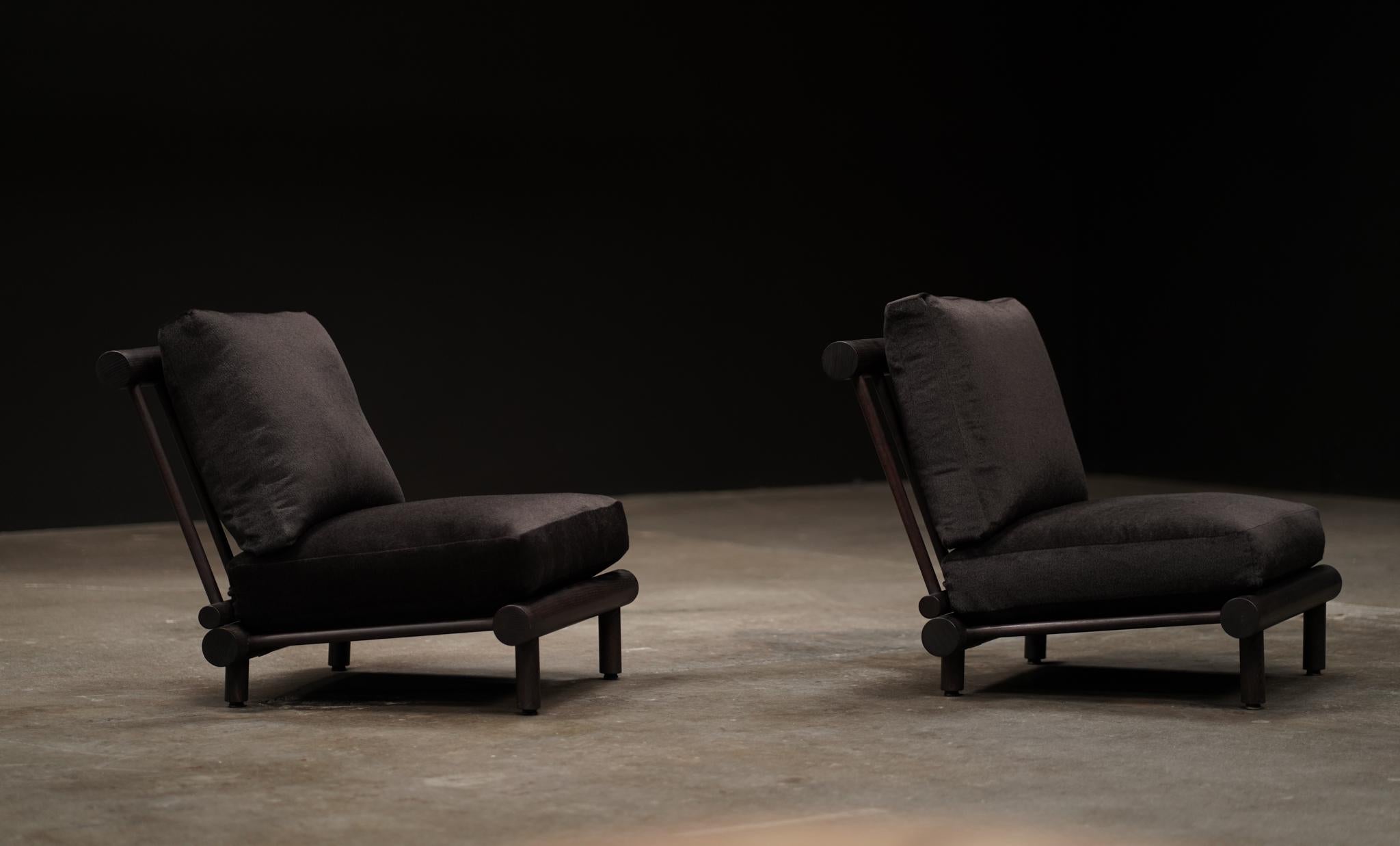 Définie par sa silhouette sculpturale et ses matériaux élémentaires, la chaise La Cachette incarne une sophistication tranquille. Son profil bas et son cadre angulaire à dos exposé créent une présence ancrée à la frontière de deux styles - une pièce