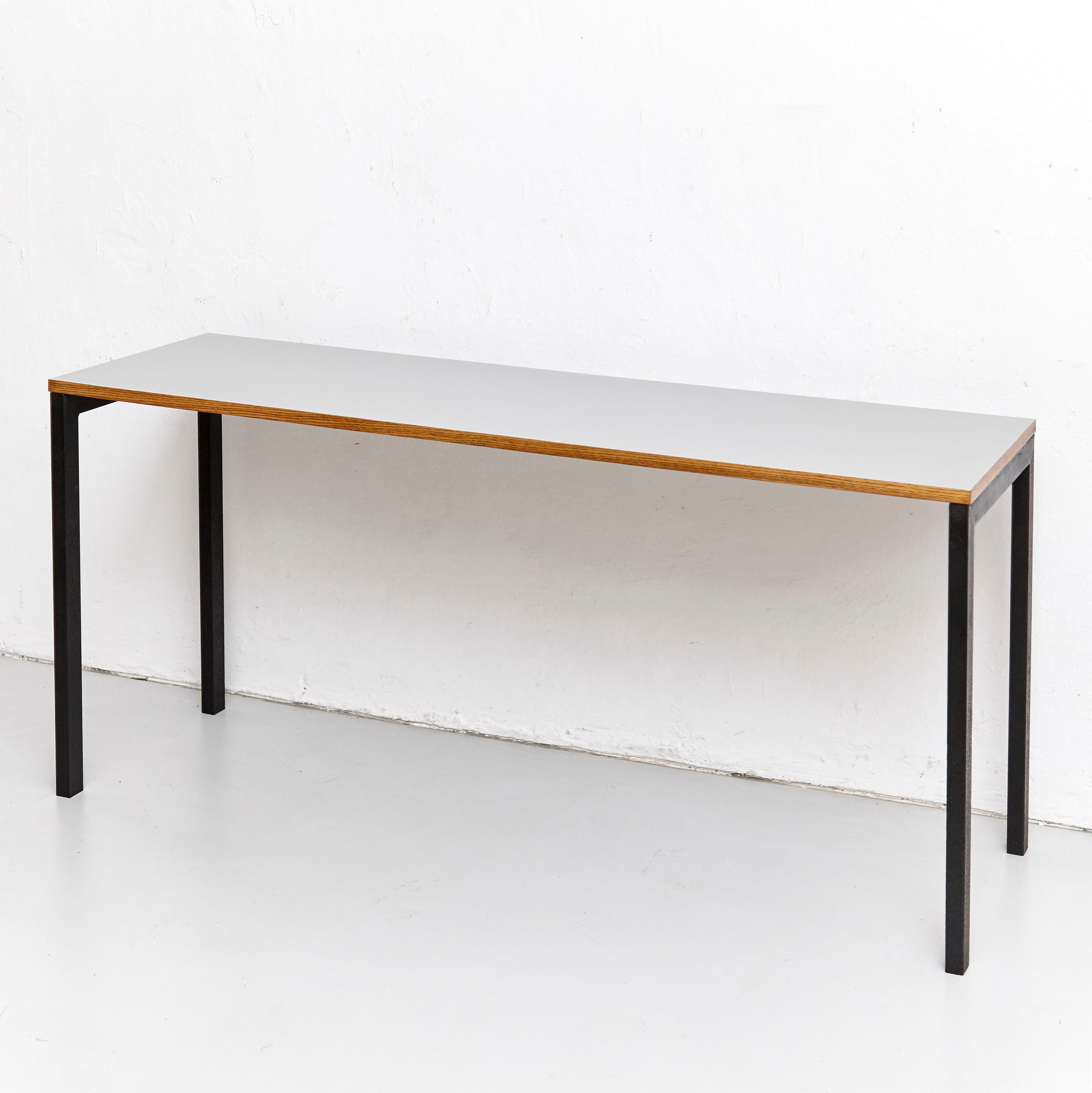Console designed by Charlotte Perriand, circa 1950.
Manufactured in France, circa 1950.
Black laminated plastic-covered plywood, painted steel.

In good original condition, with minor wear consistent with age and use, preserving a beautiful