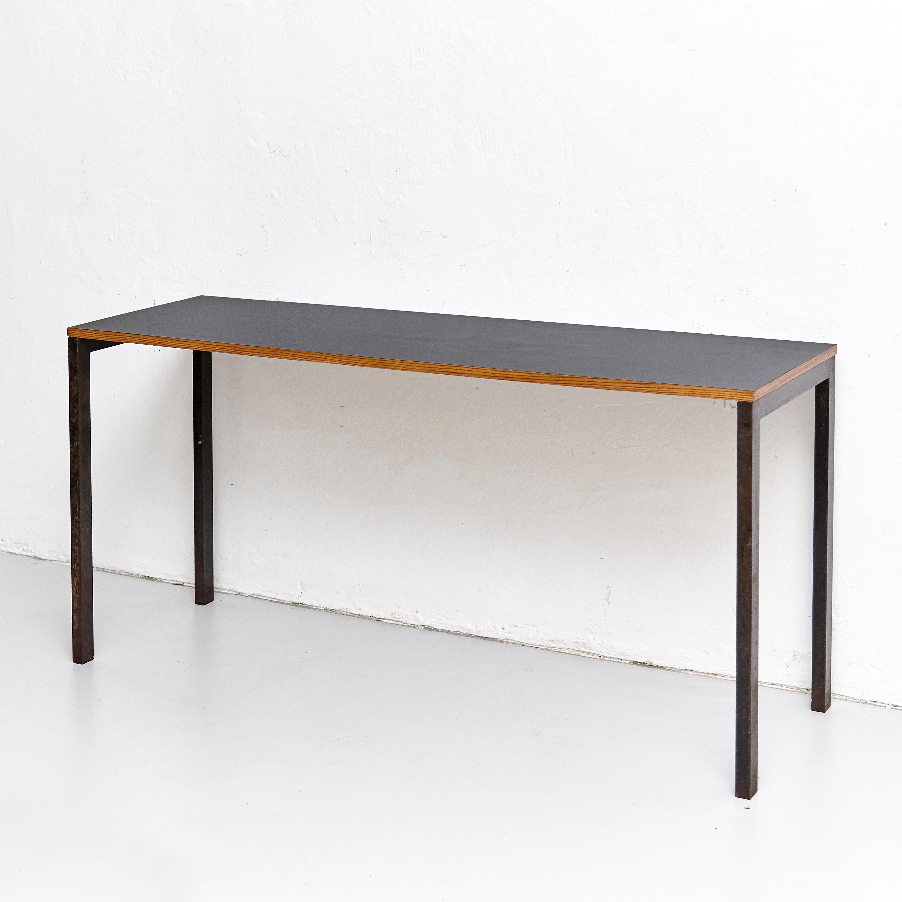 Console designed by Charlotte Perriand, circa 1950.
Manufactured in France, circa 1950.
Black laminated plastic-covered plywood, painted steel.

In good original condition, with minor wear consistent with age and use, preserving a beautiful