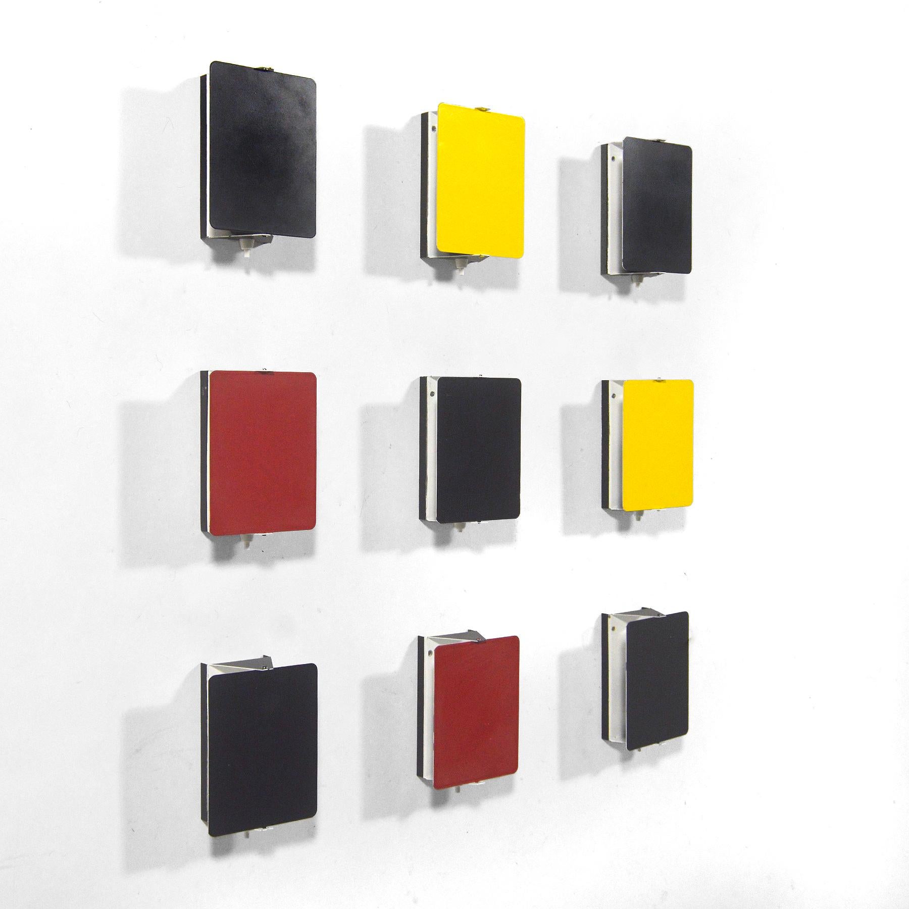 This spectacular set of Perriand wall sconces is exceptional not only for the number of lamps, but the inclusion of lamps in uncommon red, yellow, and particularly gray. A brilliant minimal design by Perriand, the pivoting shades shield glare and