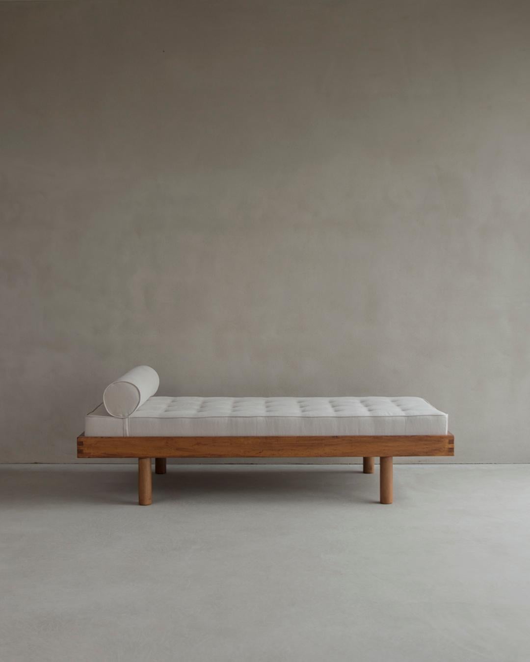 This daybed was designed by Charlotte Perriand, renowned French architect and designer, who drew it to furnish the ski resort Les Arcs 1800 in the 1970s. It is derived from a bed she designed with Le Corbusier for the Maison du Brésil in 1959. The