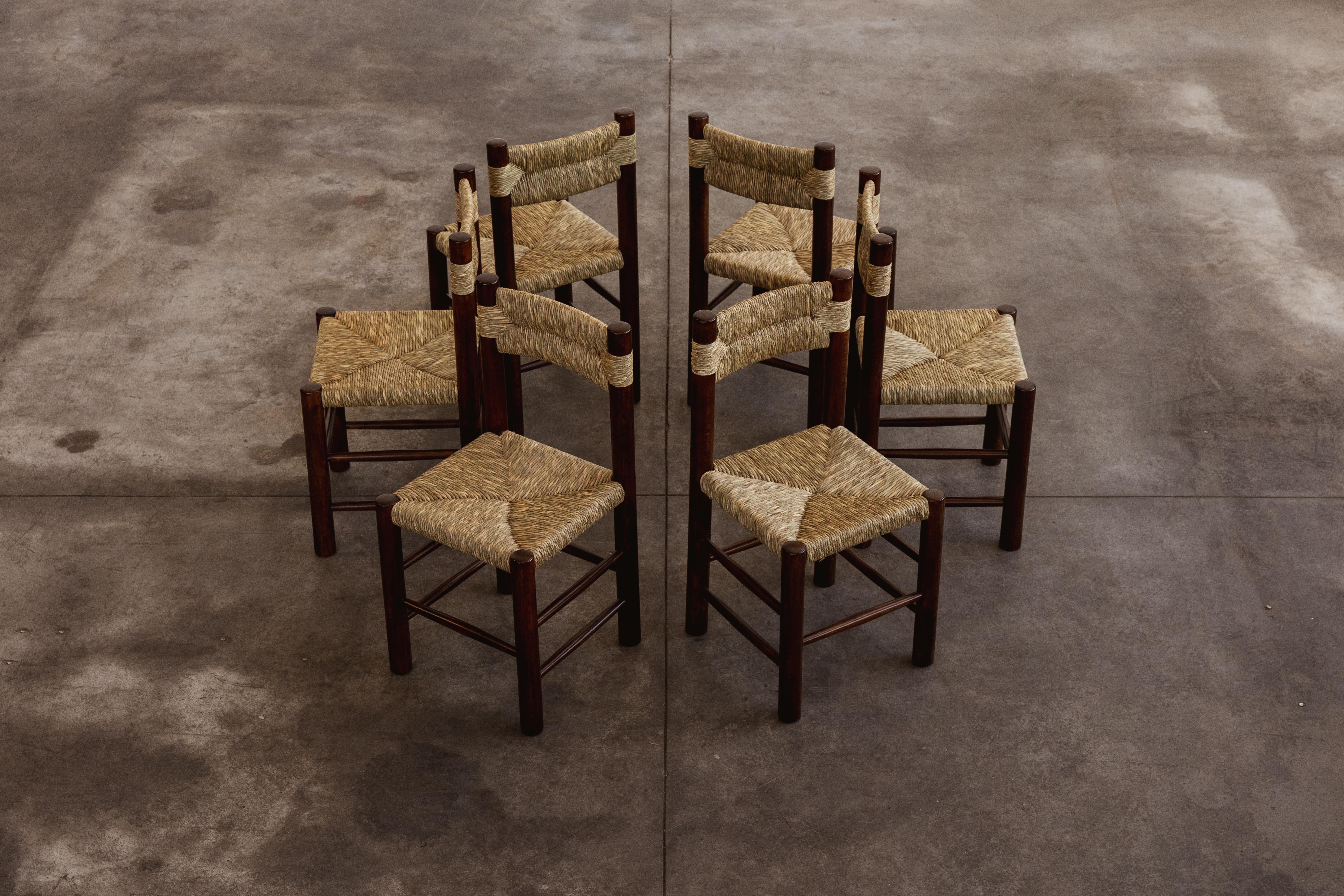Sedie da pranzo Charlotte Perriand per Robert Sentou, paglia e legno, Francia, 1964, set di sei. 

Le sedie hanno un design semplice e senza tempo. Lo schienale e la seduta in paglia, combinati con la struttura in legno di pino, formano una