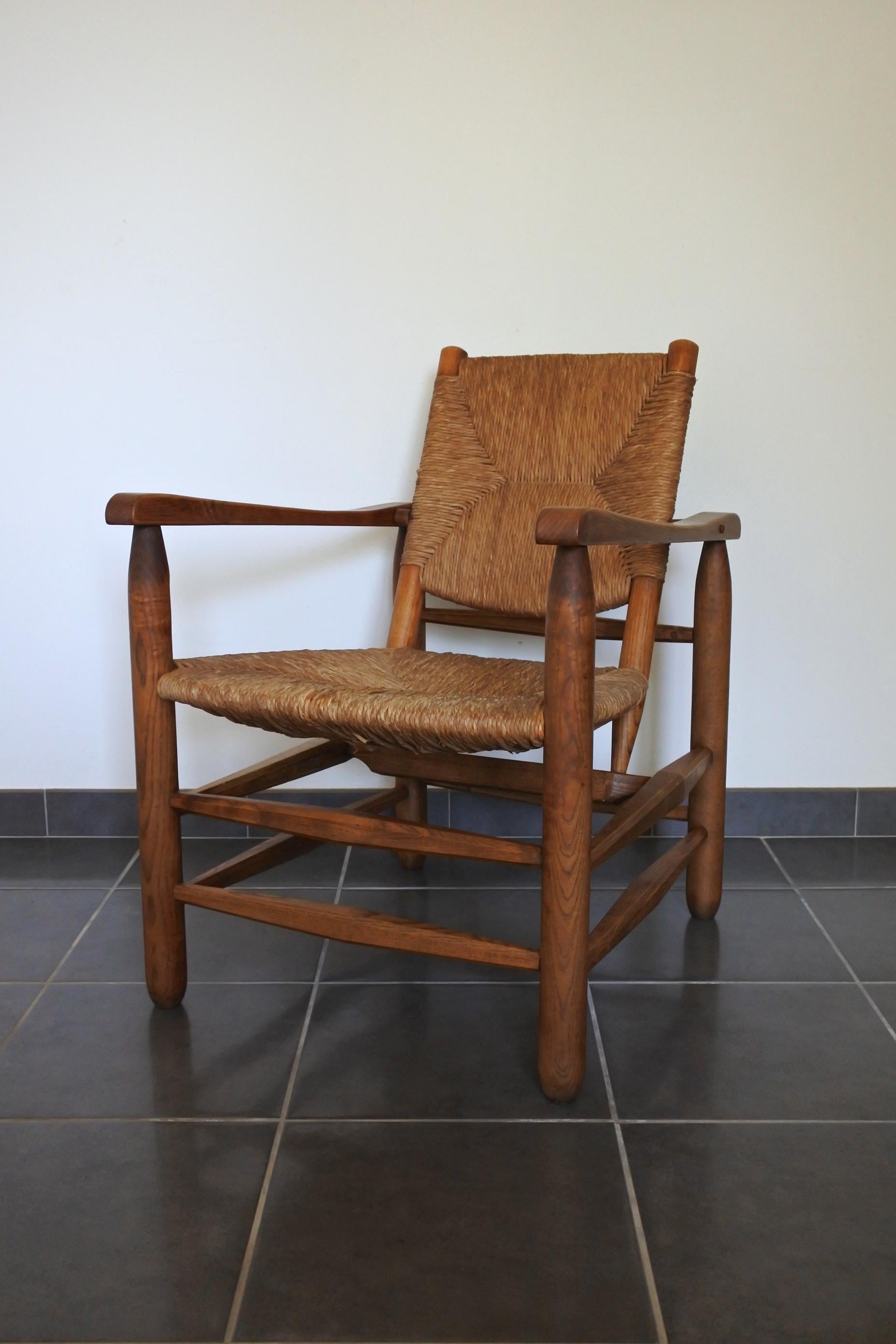 Armchair n° 21 by renowned French designer Charlotte Perriand.
Solid wood structure and wooden straw back and seat.
This lounge chair is an early exemplar, end of the 1940s early 1950s, made by Georges Blanchon (L'équipement de la maison).
Fully
