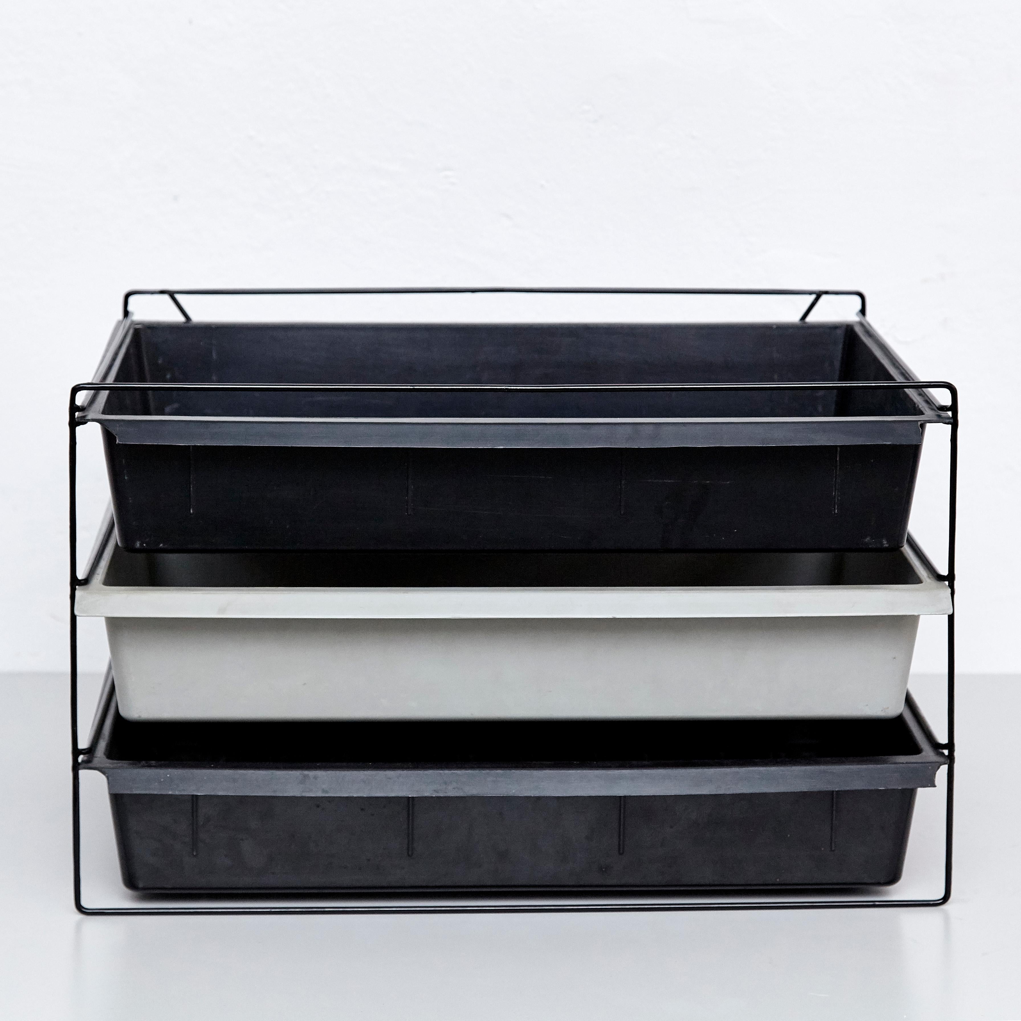 File rack designed by Charlotte Perriand, circa 1955.
Manufactured in France, circa 1955.
Moulded plastic and painted metal.

Each drawer moulded with Modele Charlotte Perriand/Brevete S.G.D.G.

In good condition, with minor wear consistent with age