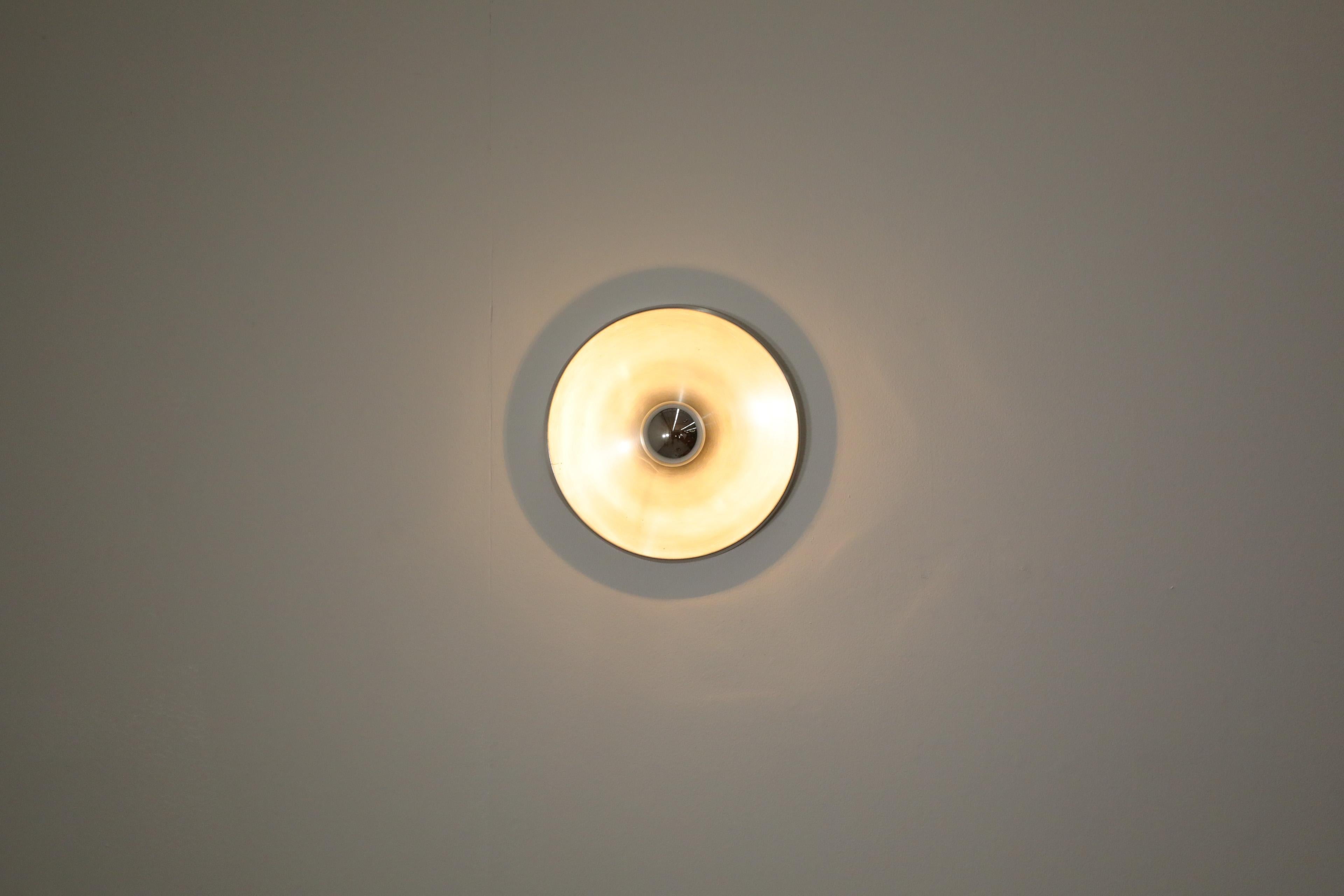 Sleekly designed Honsel Leuchten flush mount ceiling sconce. A stunning flush mount ceiling or wall light consisting of a single molded aluminum disc and shown with a silver tipped bulb. Selected by French design great Charlotte Perriand for the