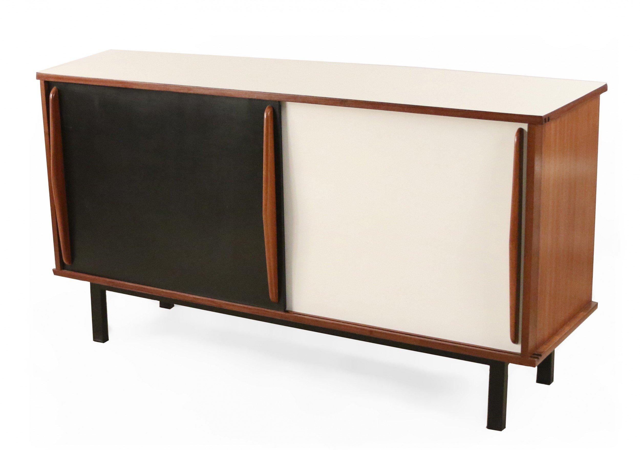 French mid-century (1950s) mahogany wood sideboard with two sliding doors with black and white formica veneer and mahogany grips, a white formica veneer top, and black lacquered metal legs. (CHARLOTTE PERRIAND FOR STEPH SIMON).
 