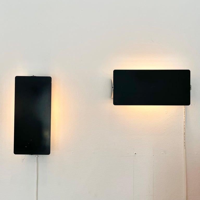 Rare large scale, enameled wall lights by Charlotte Perriand with adjustable steel reflectors in black enameled finish with two sockets each. Made in the 1960s. Optional horizontal or vertical mount. Newly rewired for US standards. Priced