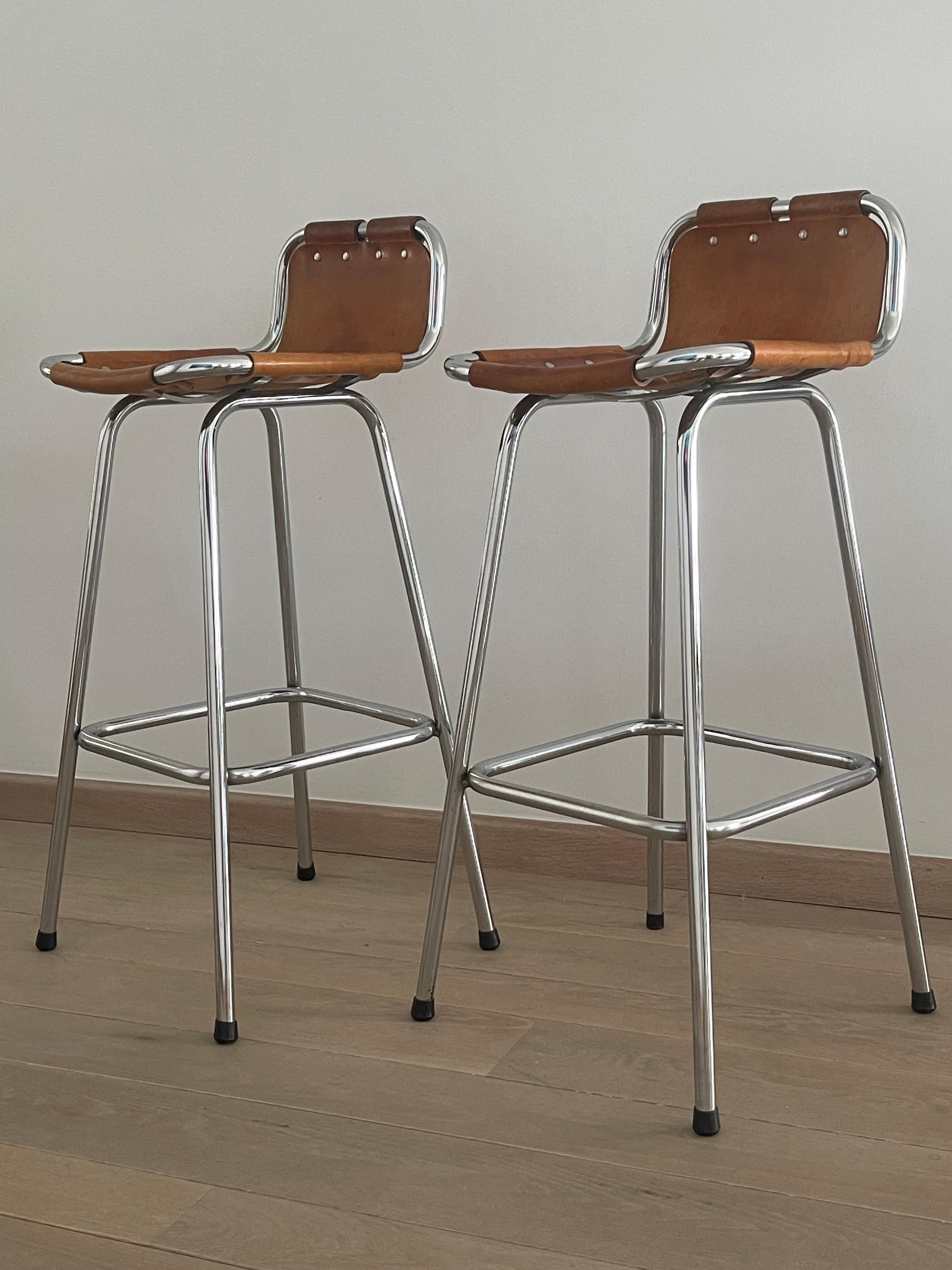 Embrace the timeless allure of mid-century modern design with this exquisite set of two Les Arcs Bar Stools, designed by renowned architect and designer Charlotte Perriand. Originally crafted for the iconic Les Arcs ski resort in the 1960s, these
