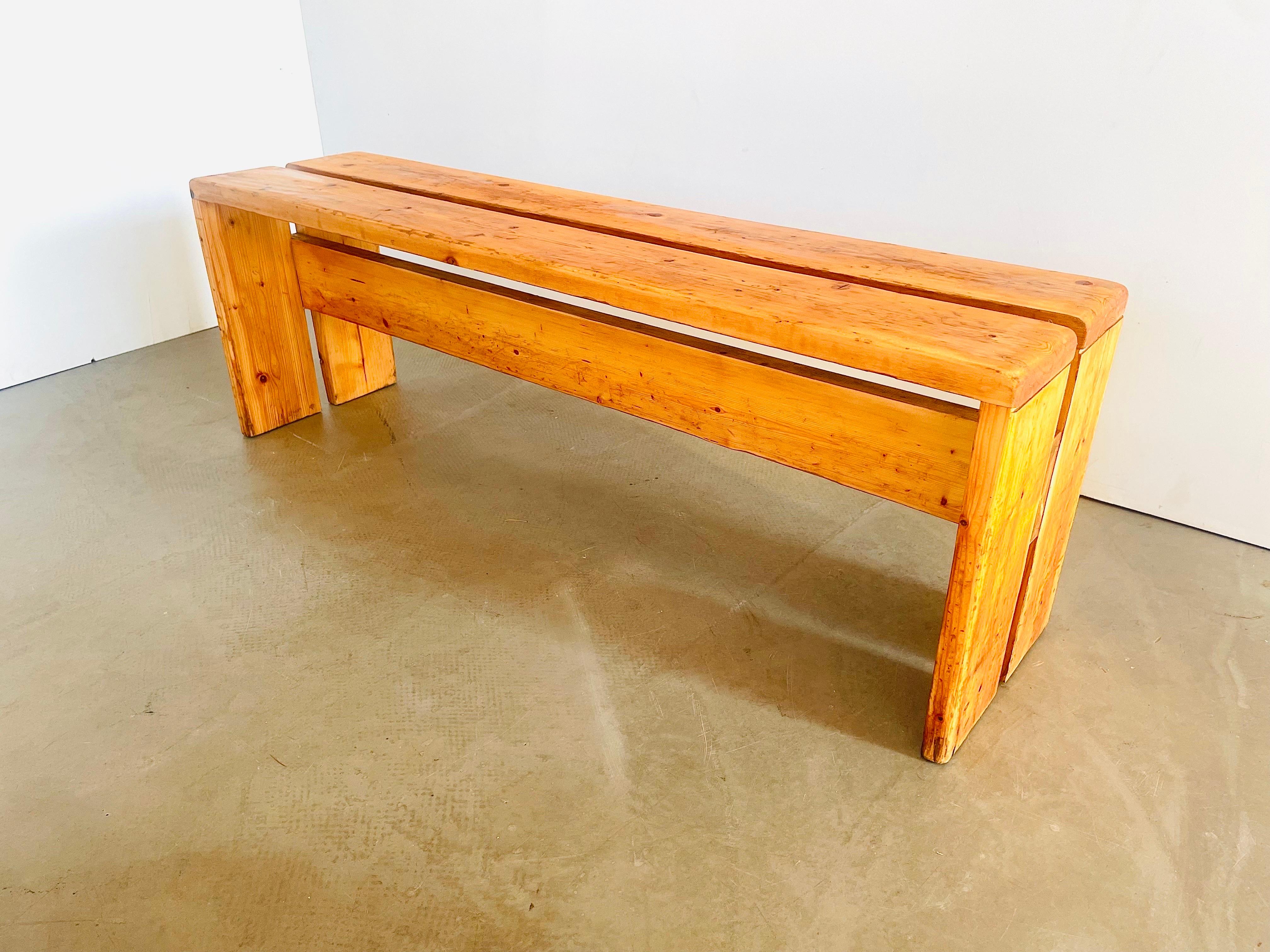 Large 3 seater bench or side table designed by Charlotte Perriand for the apartments in ski-resort Les Arcs in the French Alps. The beautiful honey-gold colored light pine wood wears a beautiful patina. Authentic piece originating from Les Arcs,