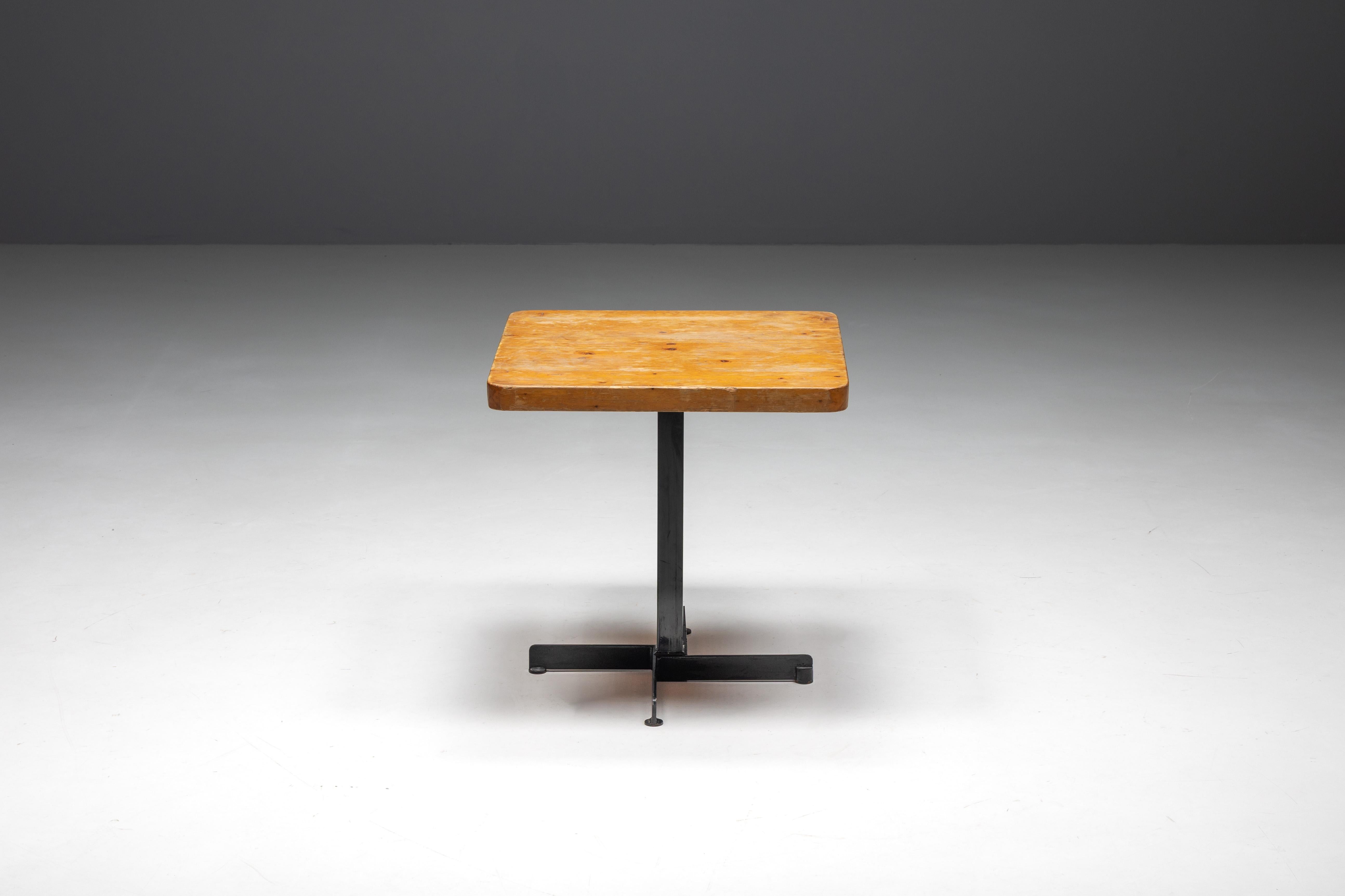 Square table by Charlotte Perriand for Les Arcs ski resort in France, embodying the timeless elegance of Mid-Century Modern dining. This table features a square pine table top gracefully supported by a sophisticated black metal frame. The tabletop
