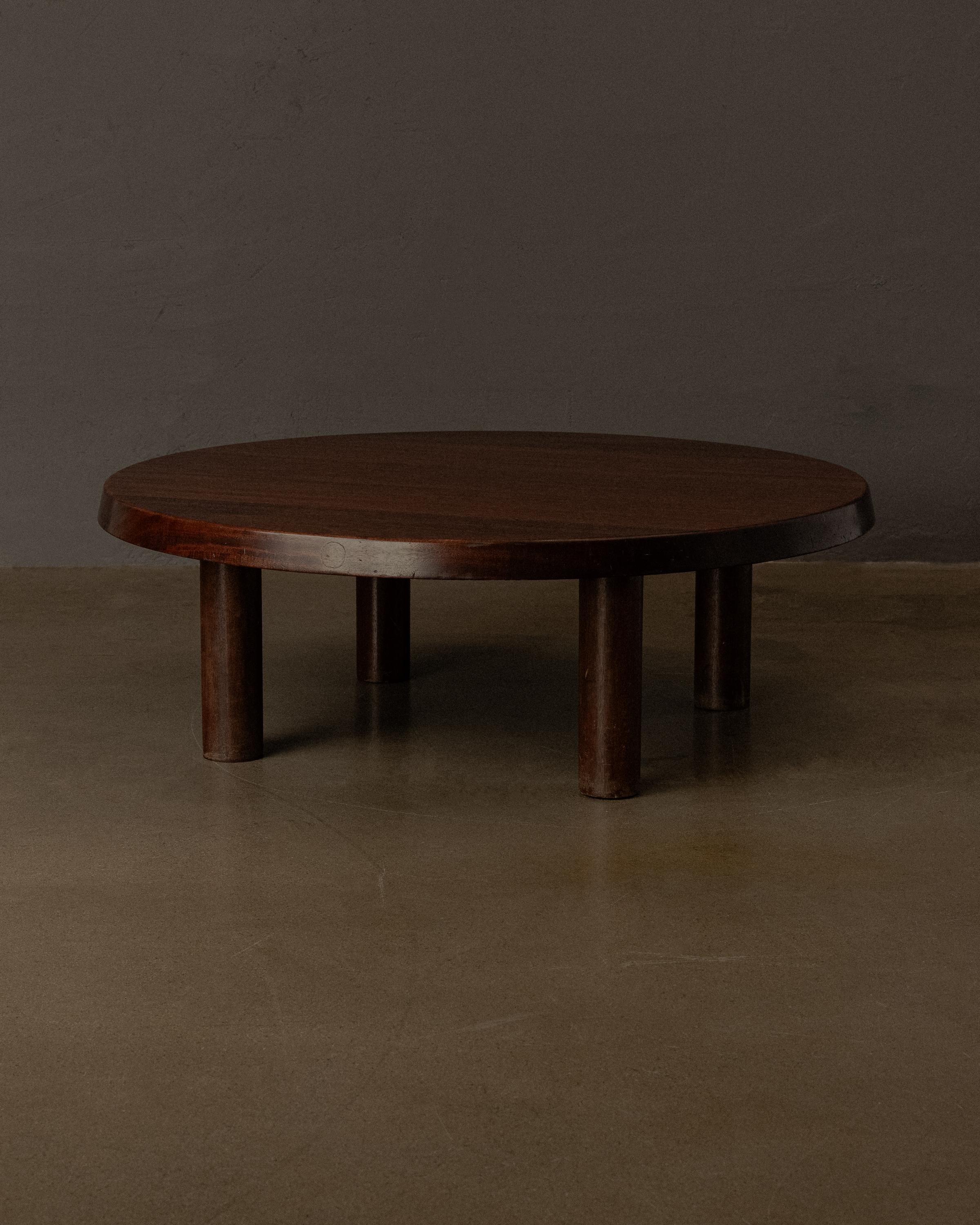 A rare and architecturally grounded low table by Charlotte Perriand. Executed in richly grained solid hardwood —  mahogany — the table showcases Perriand’s enduring commitment to honest materials and elemental forms. The generous circular top