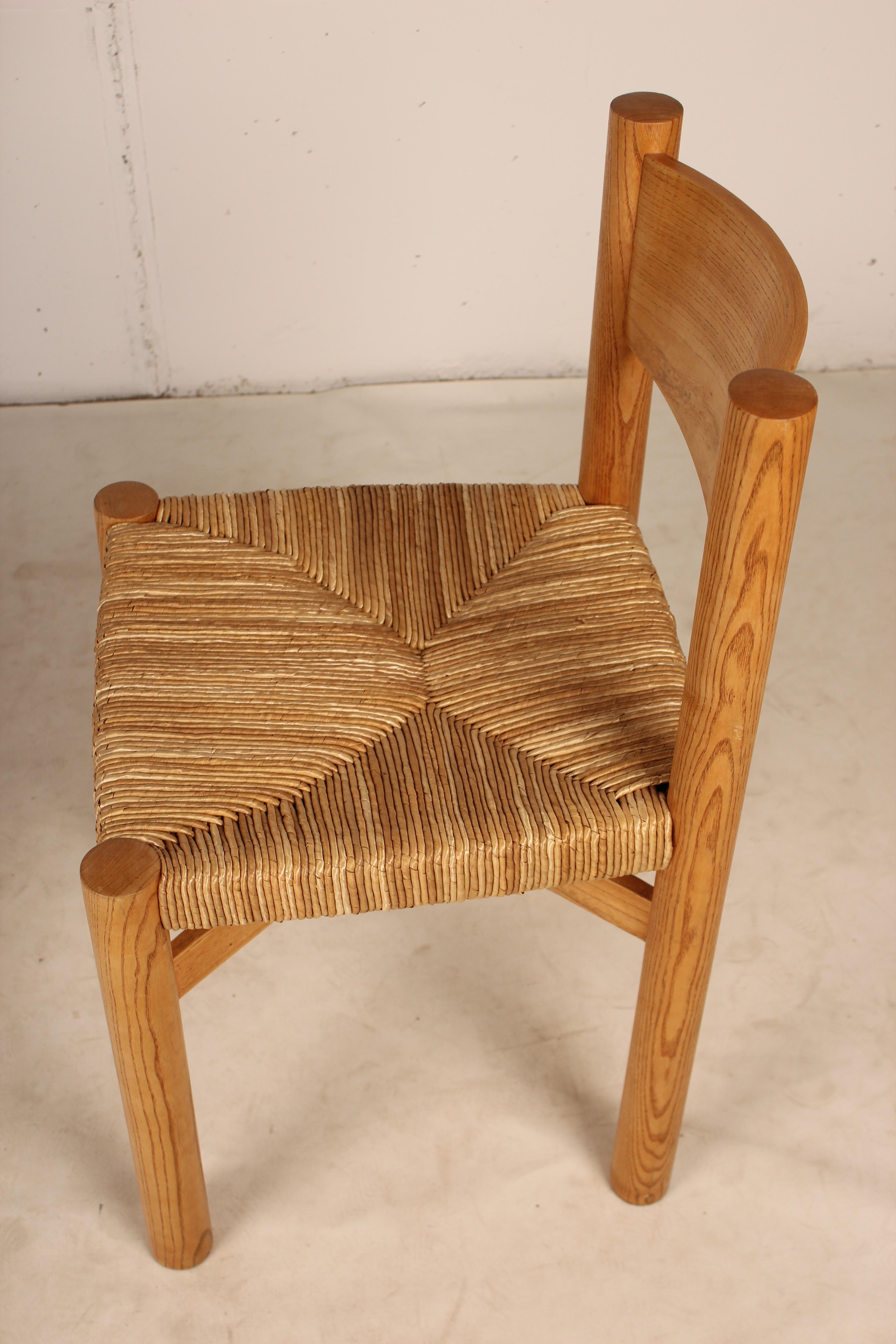 Esszimmerstuhl, Modell Meribel, entworfen von Charlotte Perriand, um 1960. Hergestellt von Steph Simon (Frankreich), Sockel und Beine aus Buchenholz, Sitz aus Stroh, geschwungene Rückenlehne, Beine aus Holz, die durch einen X-Abstandhalter unter der