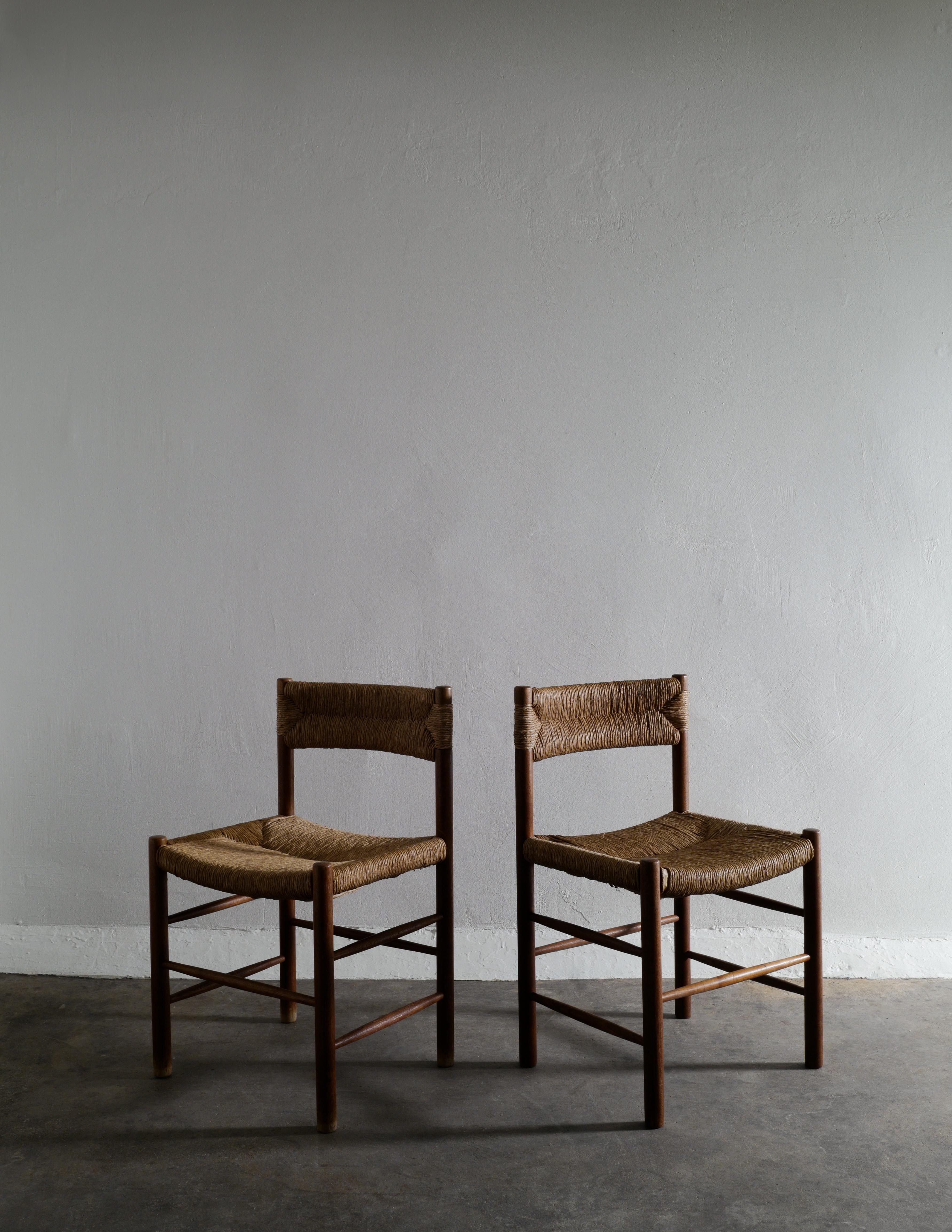 Rare set of four dining chairs designed by Charlotte Perriand produced for Robert Sentou in France in the 1960s. In good vintage and original condition with signs from age and use. Aquired from a private collection. 

Dimensions: H: 76 cm W: 47 cm